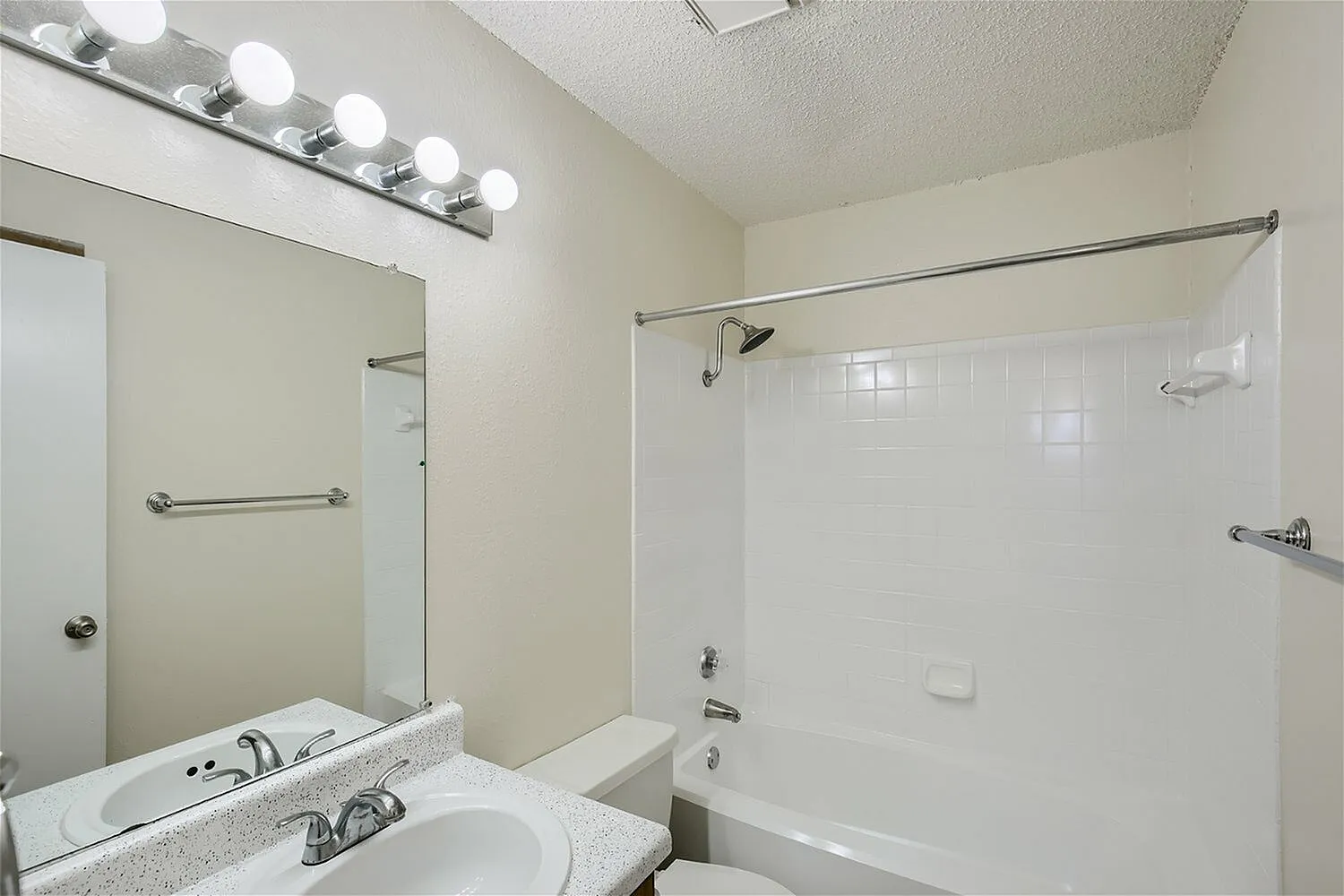 Primary bathroom, vanity with granite countertop, vessel sink, glass shower enclosure, lighting fixtures