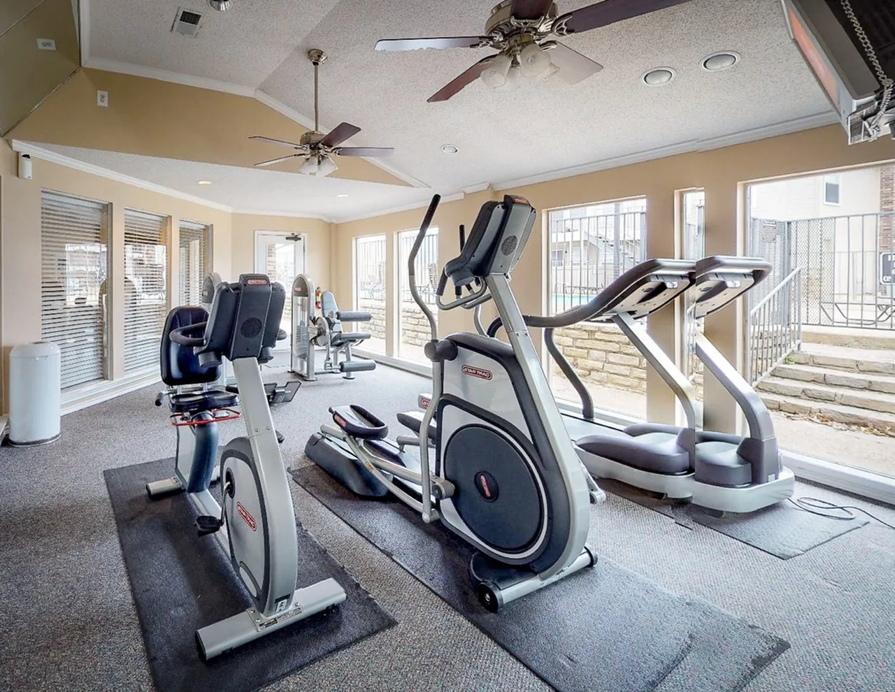 Fitness center, stationary bikes, elliptical machines, ceiling fans, large windows