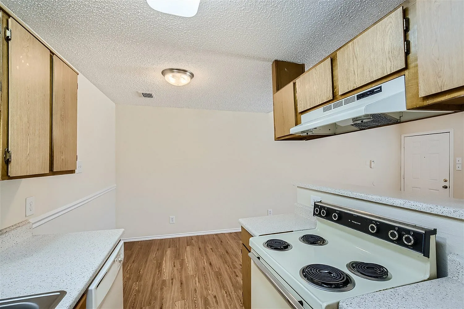Kitchen, wood cabinetry, quartz countertops, white electric range, wood-style plank flooring