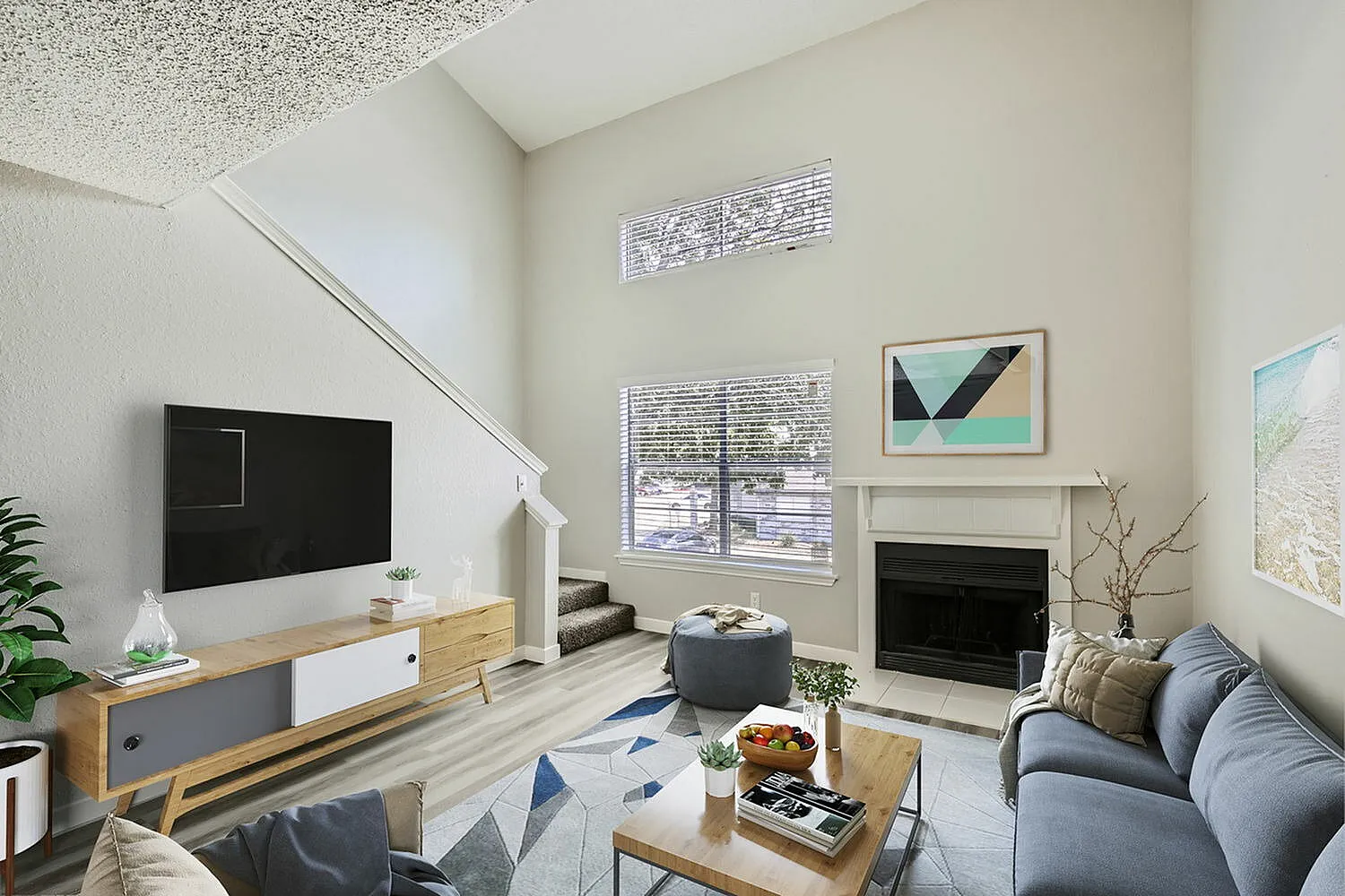 Living room, wood-style plank flooring, fireplace, black television, geometric area rug