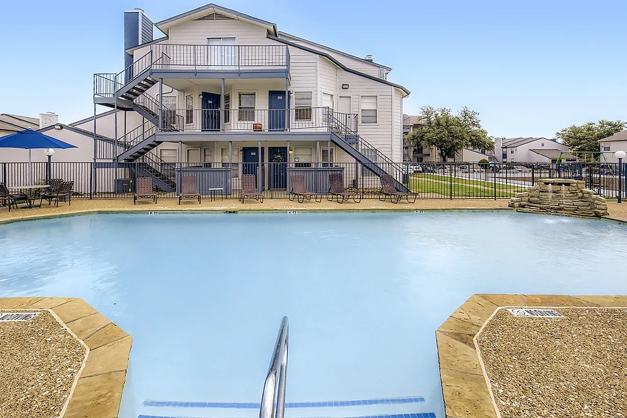 Resort-style swimming pool, sandy entry, metal railings, Mesquite TX