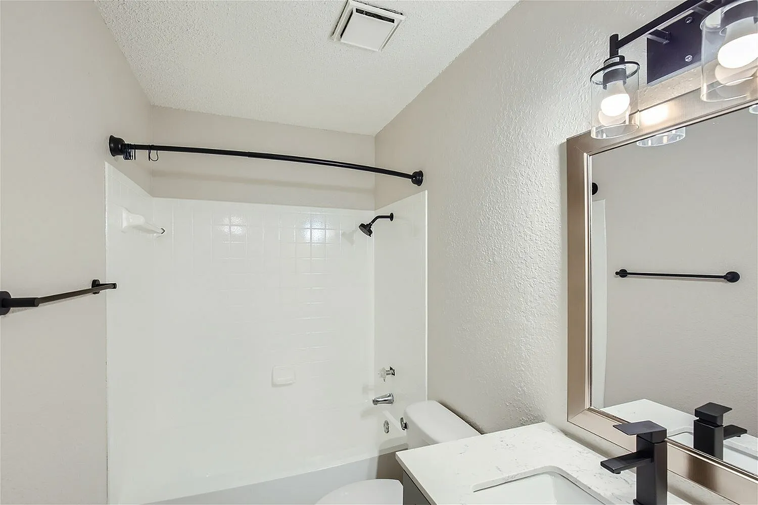 Bathroom, white vanity sink, framed mirror, black fixtures and hardware