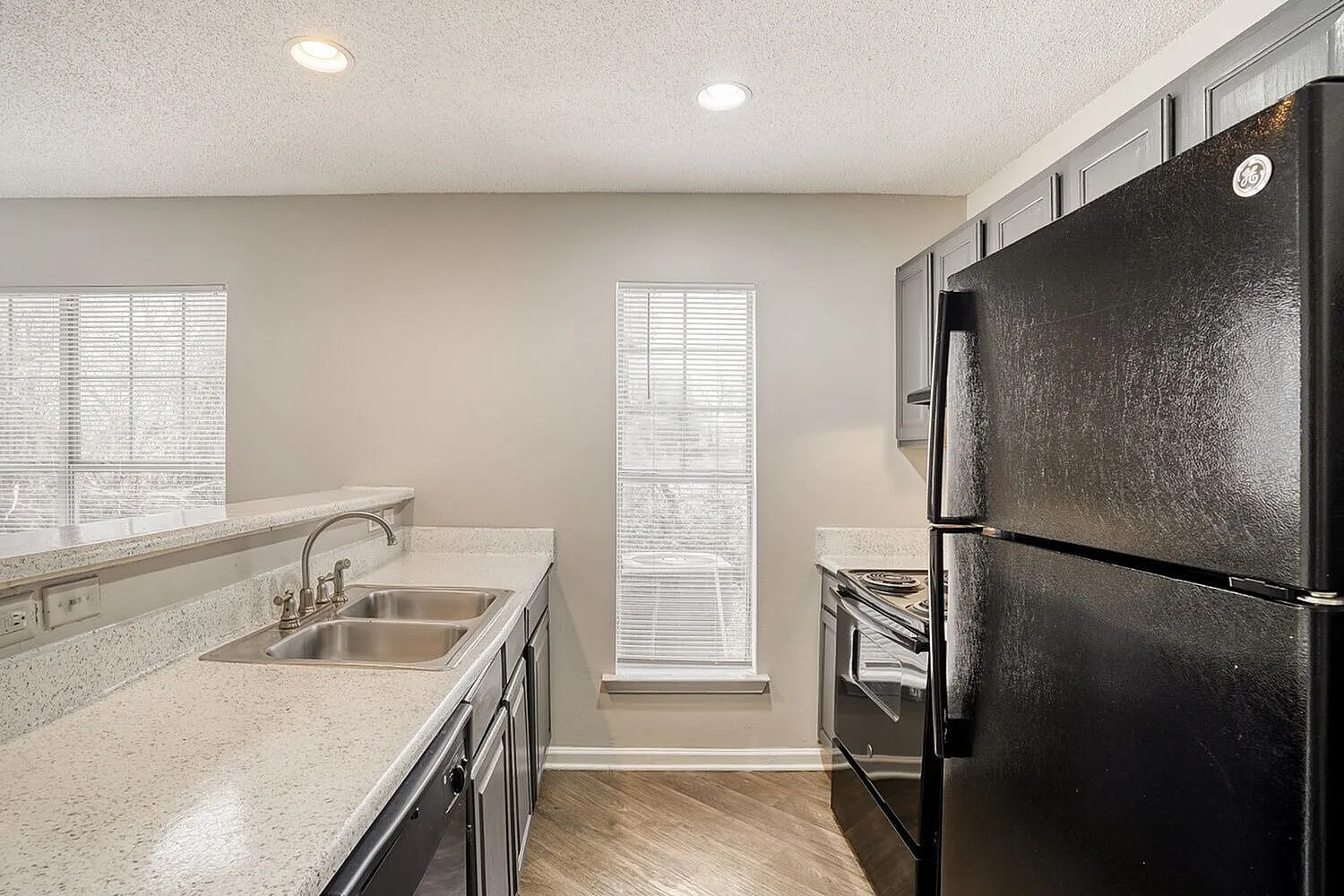 Kitchen, quartz countertops, stainless appliances, dark cabinetry, wood-style plank flooring