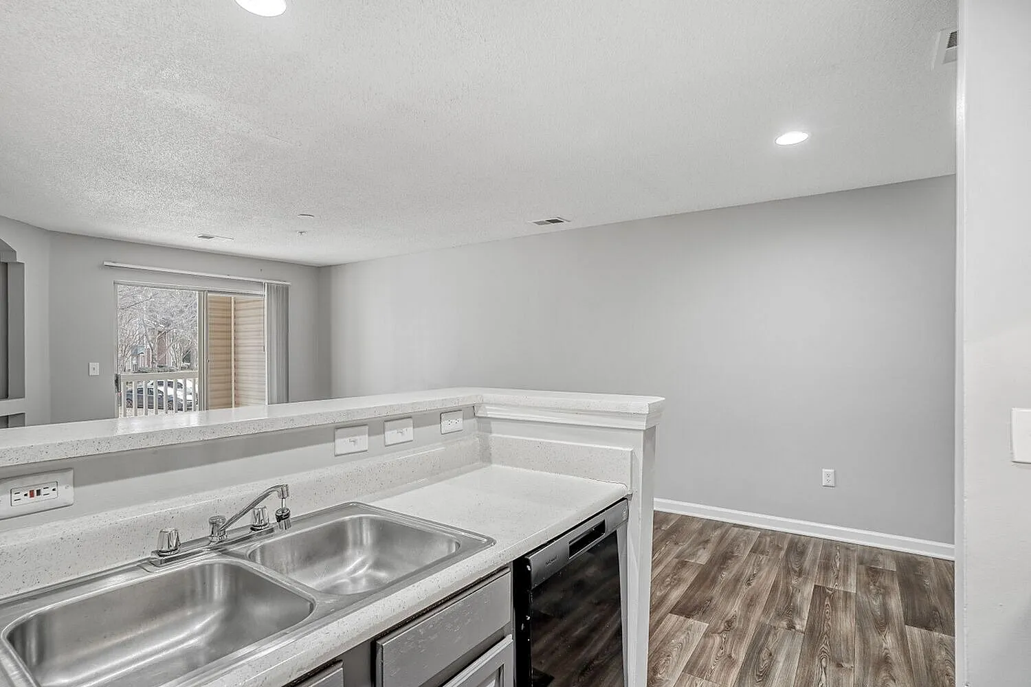 Kitchen, white quartz countertops, stainless steel double sink, black electric range, wood-style plank flooring