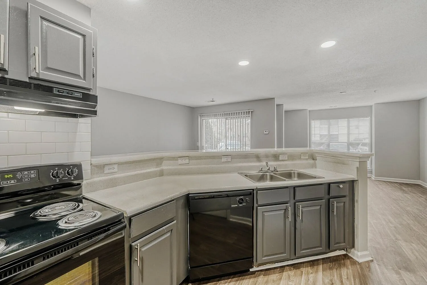 Kitchen, gray shaker cabinetry, quartz countertops, stainless appliances, wood-style plank flooring