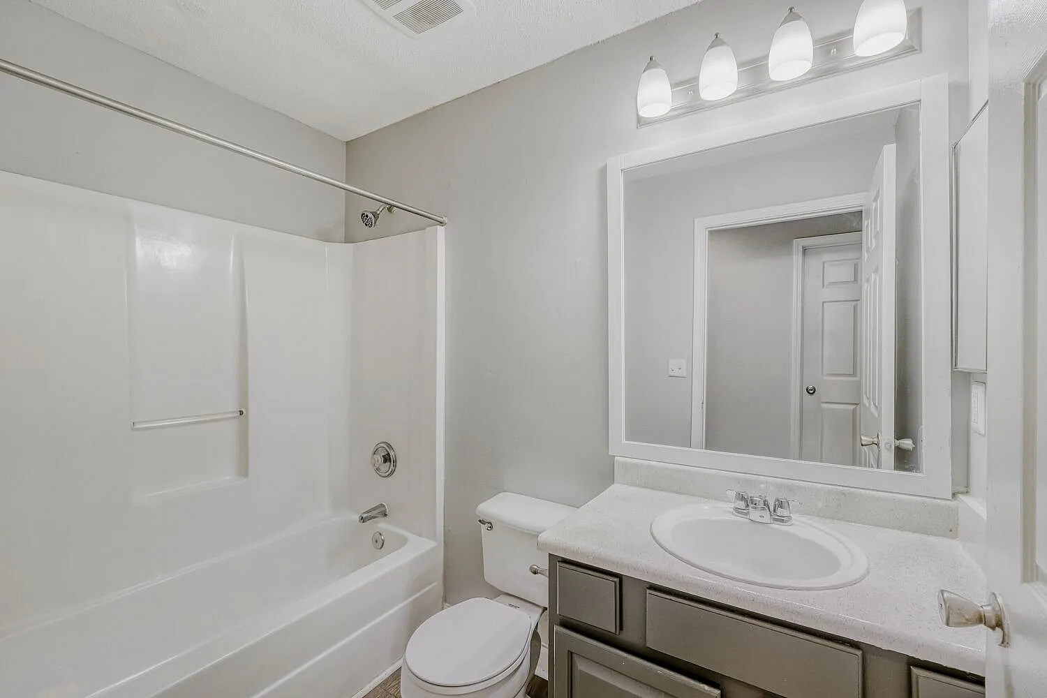 Bathroom, white sink vanity, framed mirror, brushed nickel fixtures, white subway tile surround