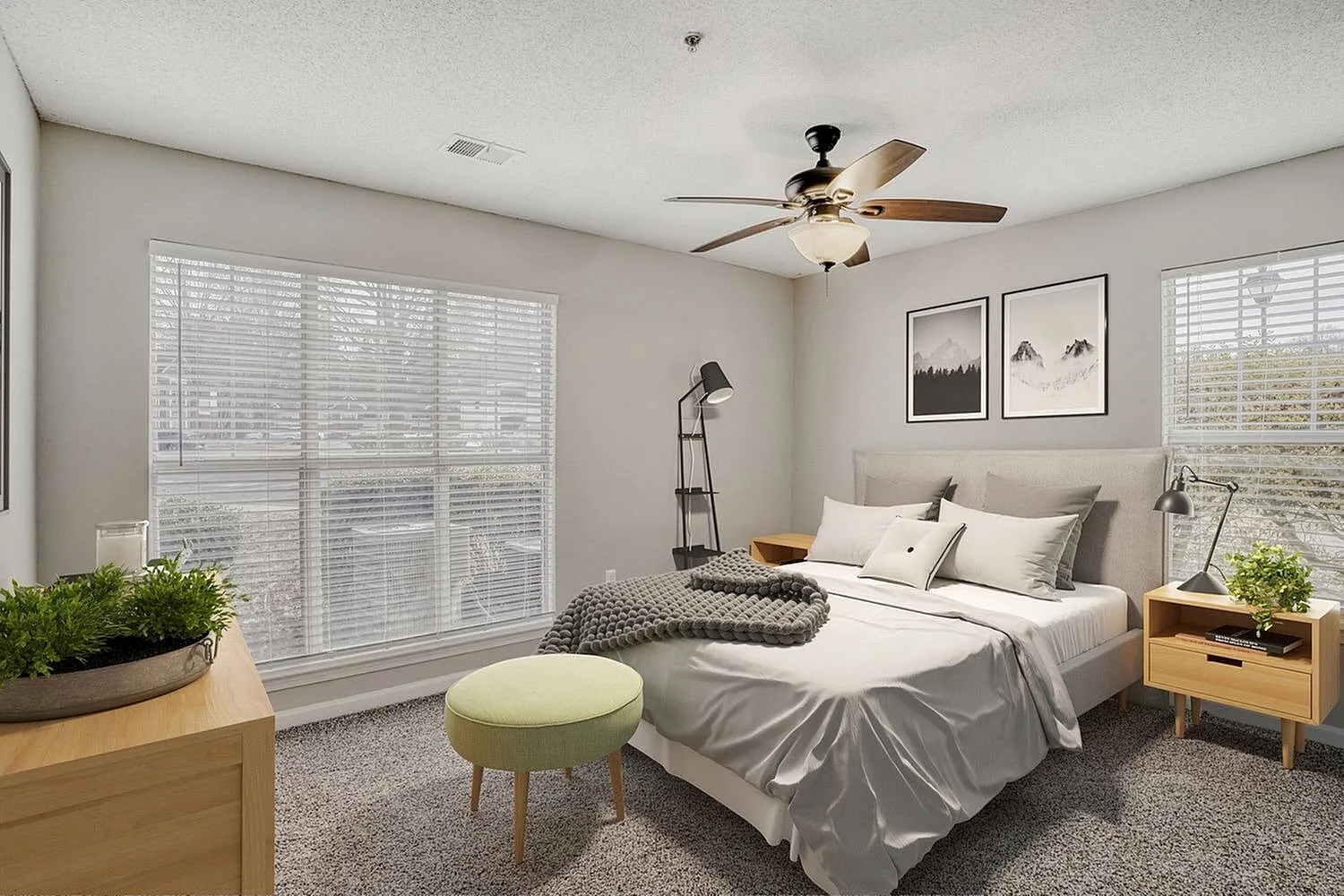 Primary bedroom, gray upholstered headboard, white bedding, wood-style nightstands, ceiling fan, shuttered windows