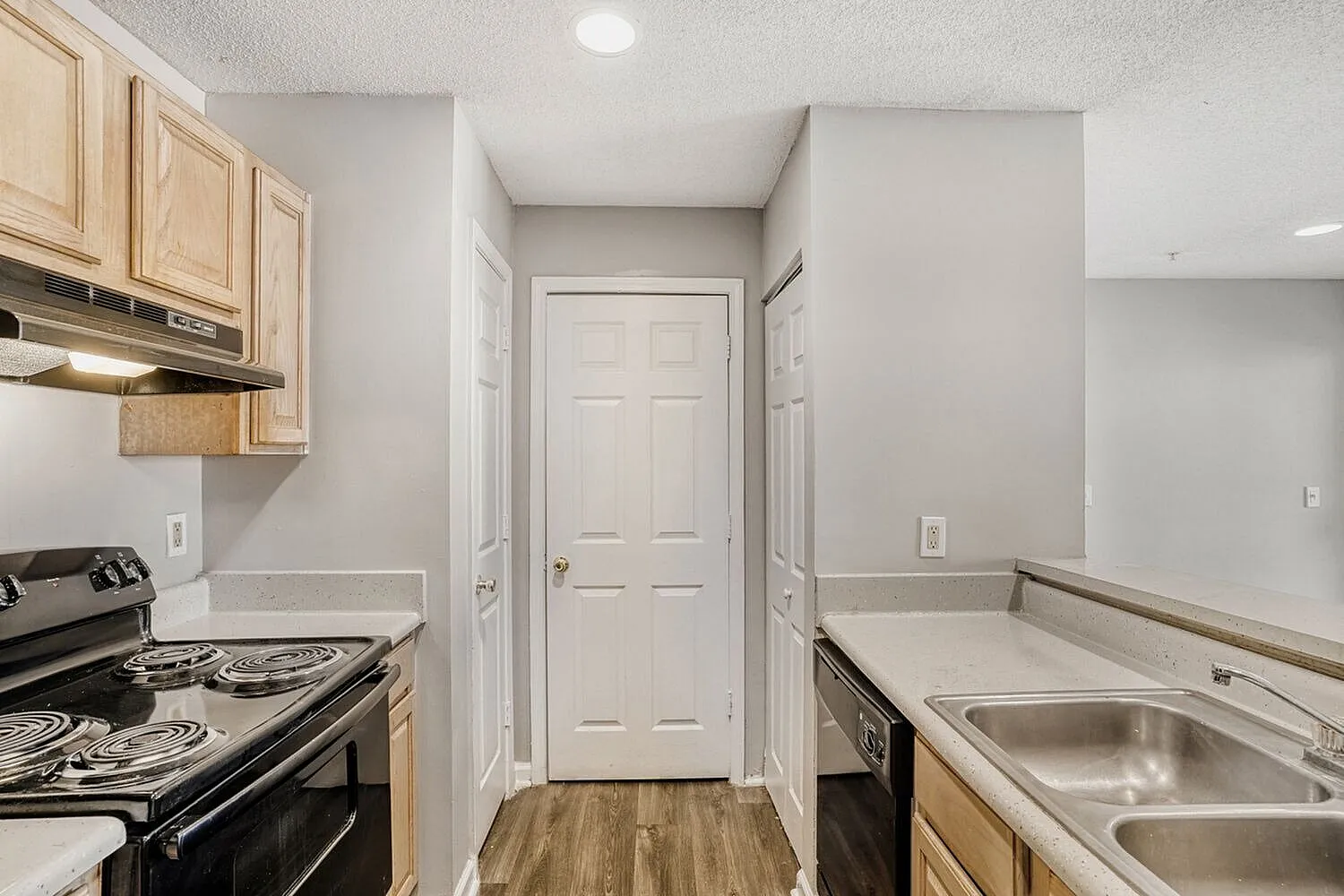 Kitchen, wood-style plank flooring, stainless steel appliances, tan cabinetry, granite countertops