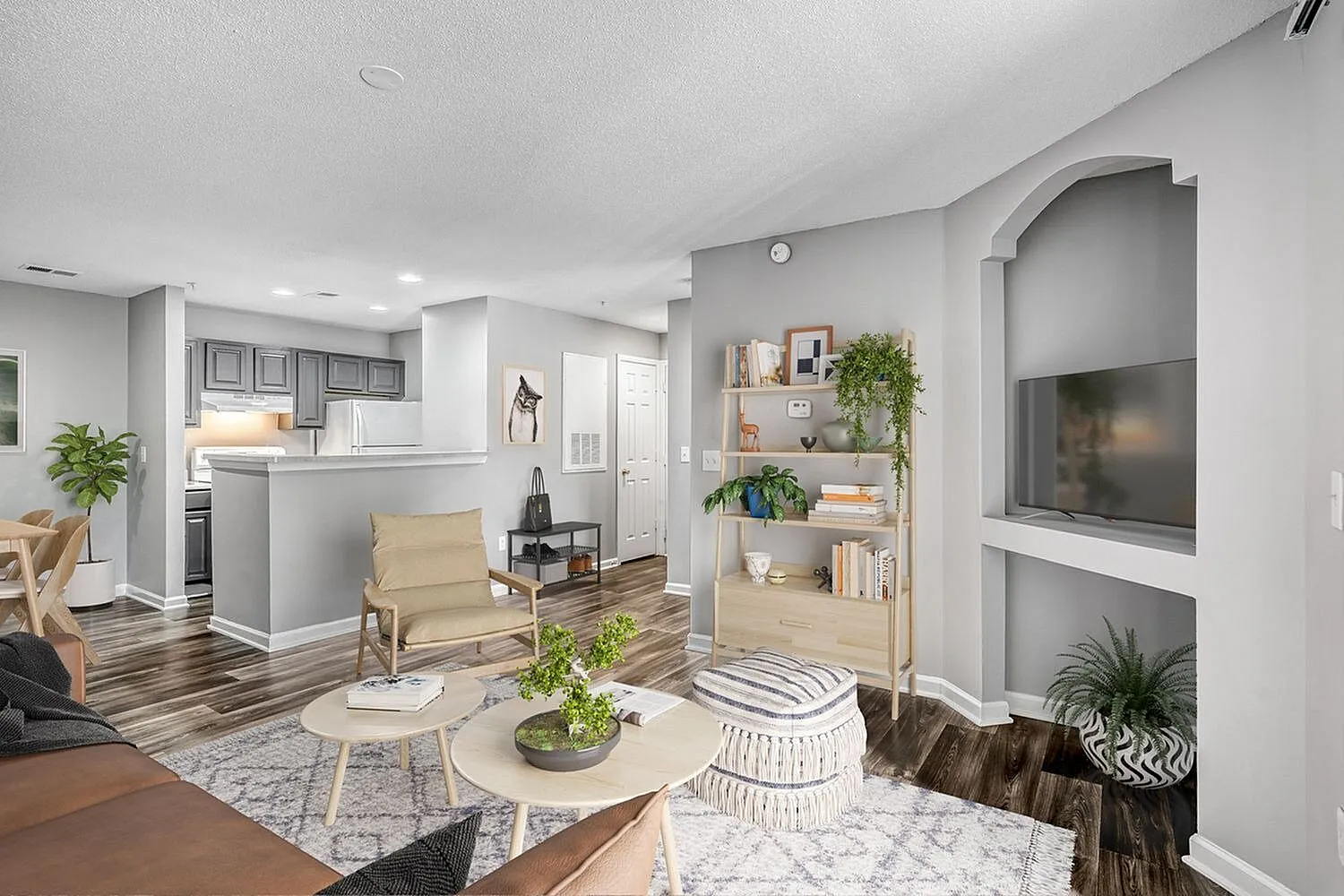 Open living room, wood-style plank flooring, built-in shelving with plants, modern furnishings