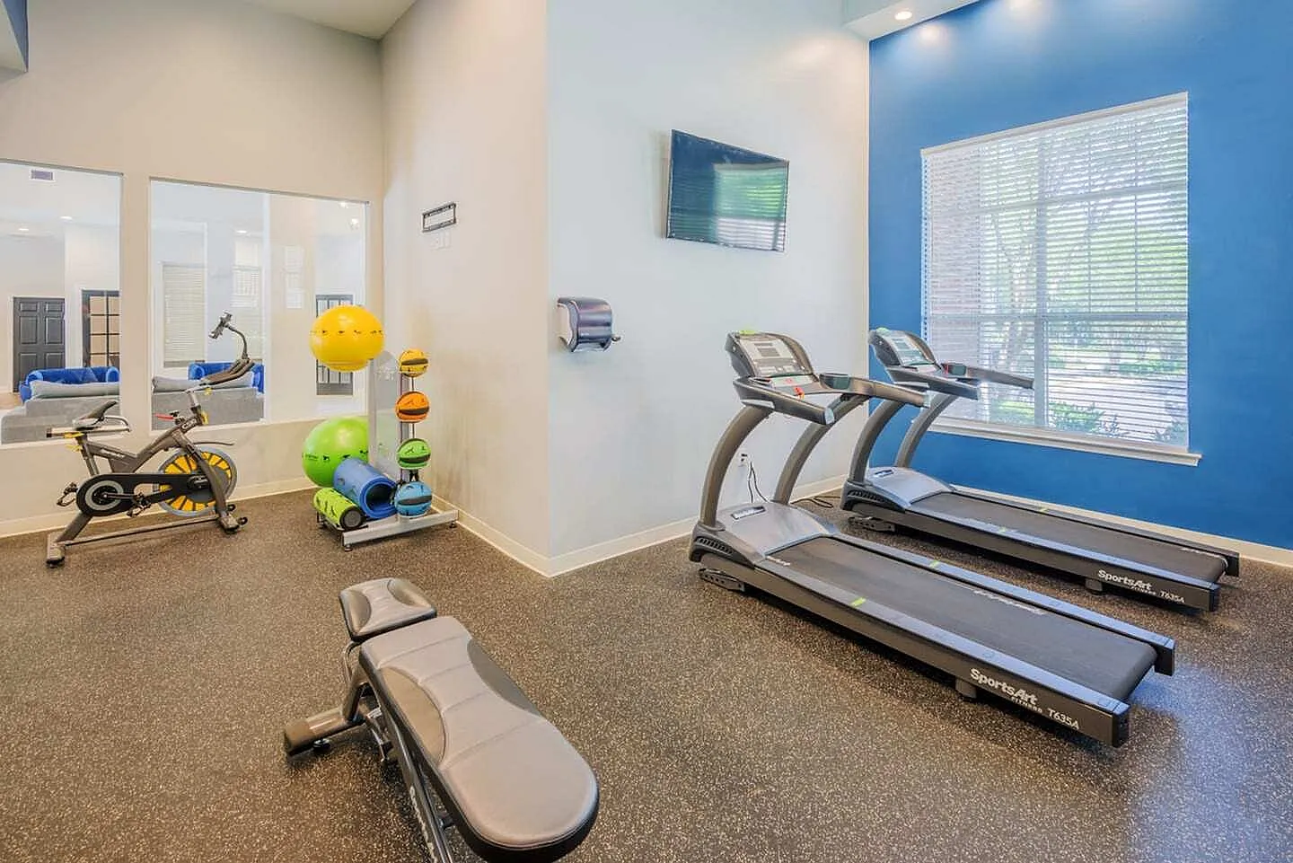 Fitness center, treadmills, stationary bike, exercise equipment, blue accent wall