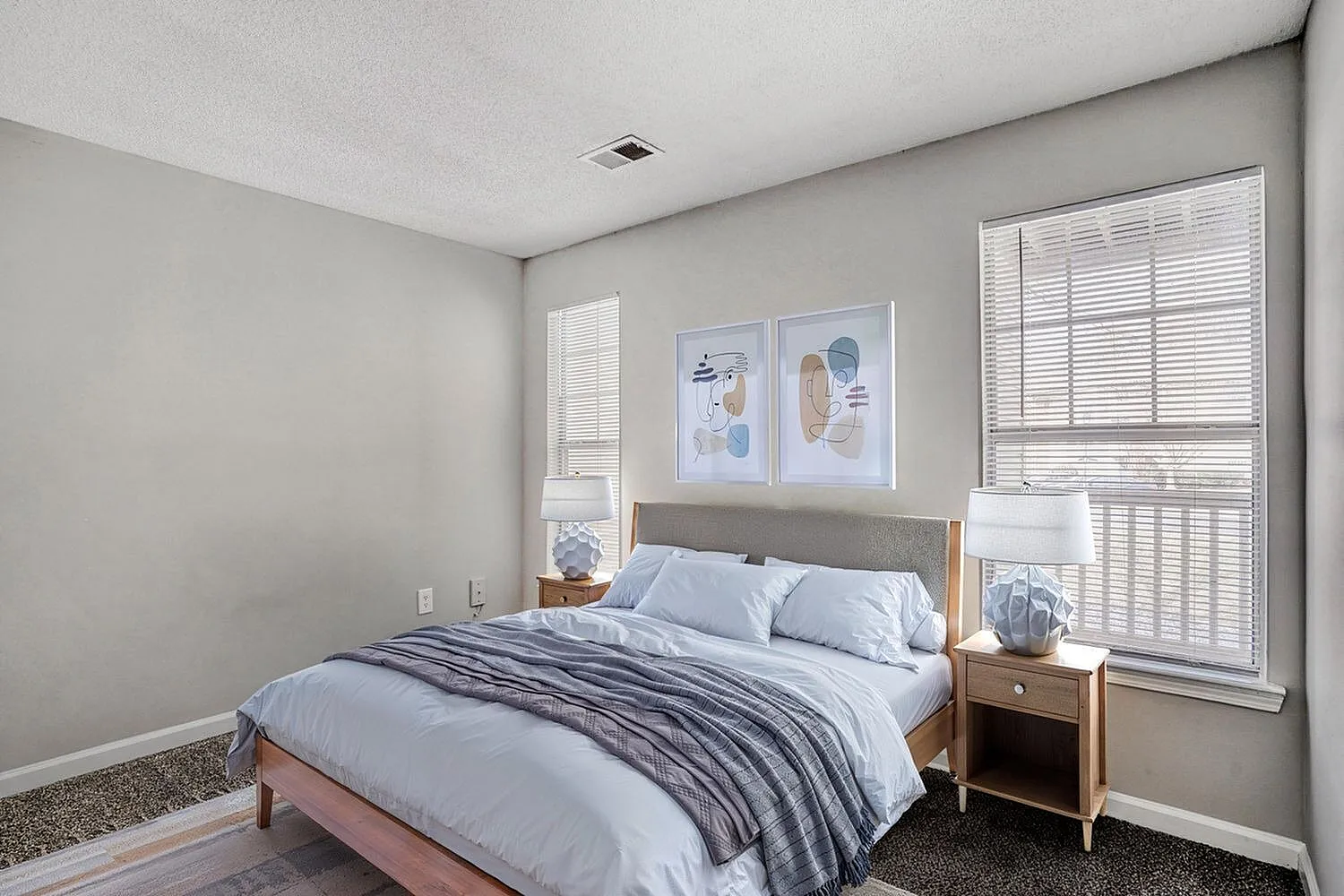 Primary bedroom, wood-style plank flooring, plantation shutters, white bedding, nightstands