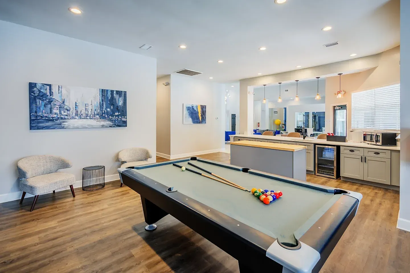 Game room, pool table, cream seating, wood-style plank flooring, kitchenette