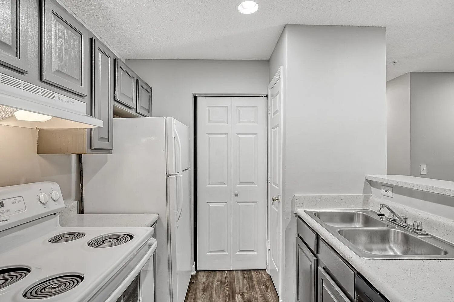 Kitchen, white coil-top range, stainless steel sink, gray cabinets, wood-style plank flooring