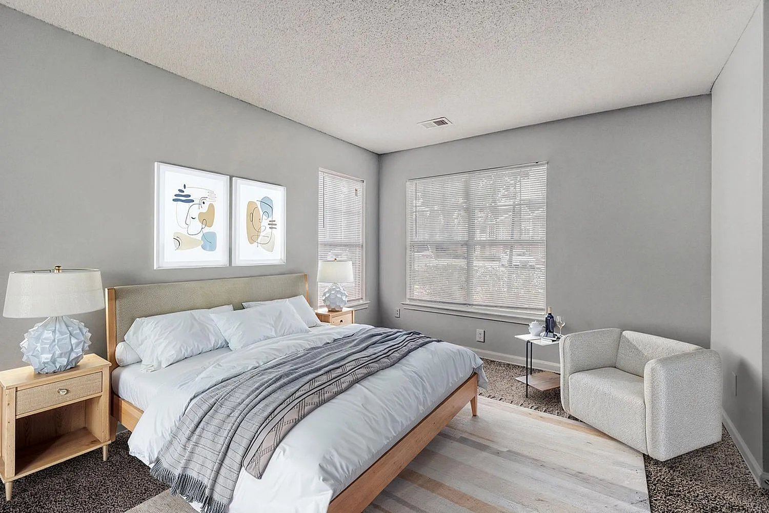 Primary bedroom, wood-style plank flooring, large windows, upholstered accent chair