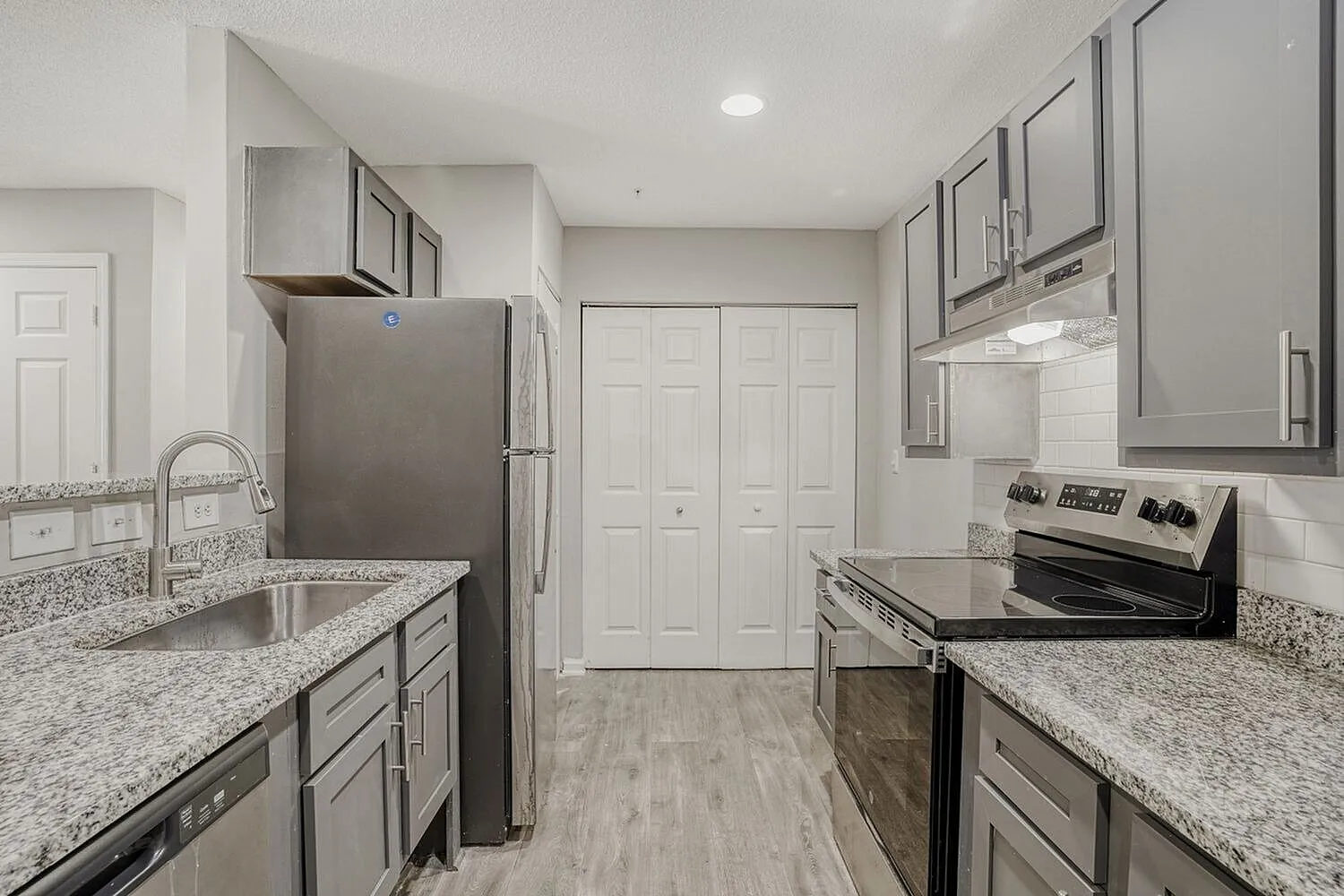 Kitchen, gray shaker cabinetry, granite countertops, stainless steel appliances, wood-style plank flooring