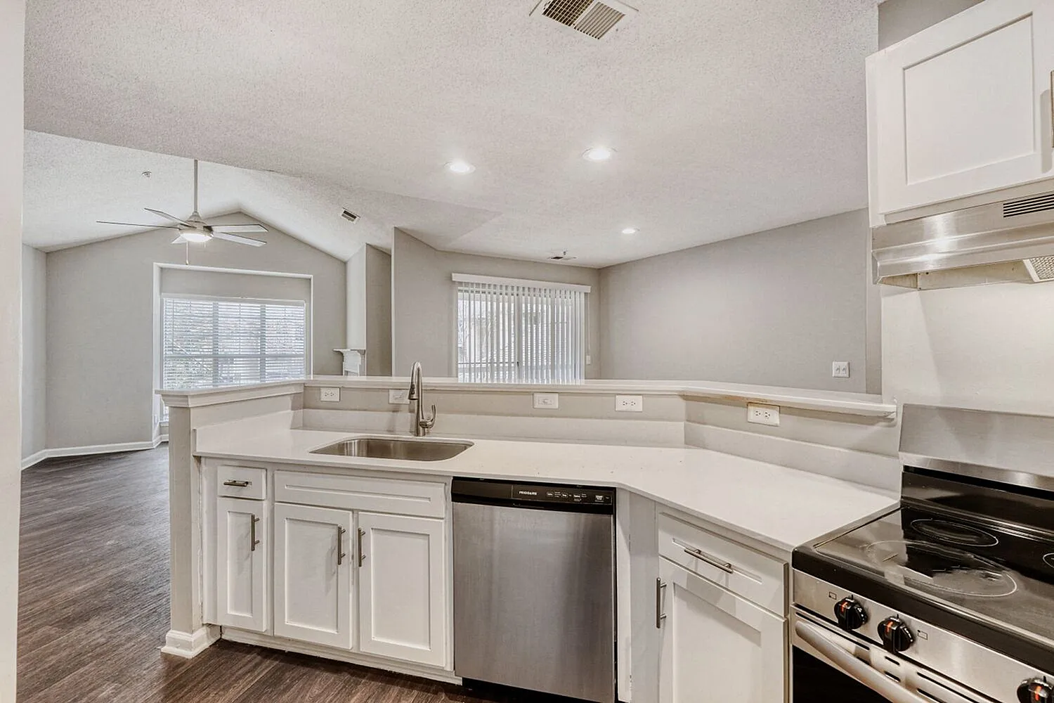 Kitchen, white shaker cabinetry, quartz countertops, stainless appliances, wood-style plank flooring