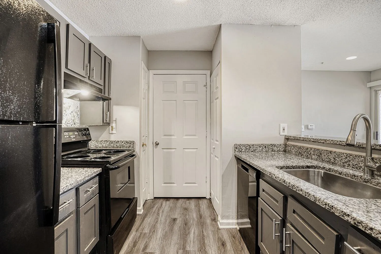 Kitchen, granite countertops, shaker cabinetry, stainless appliances, wood-style plank flooring