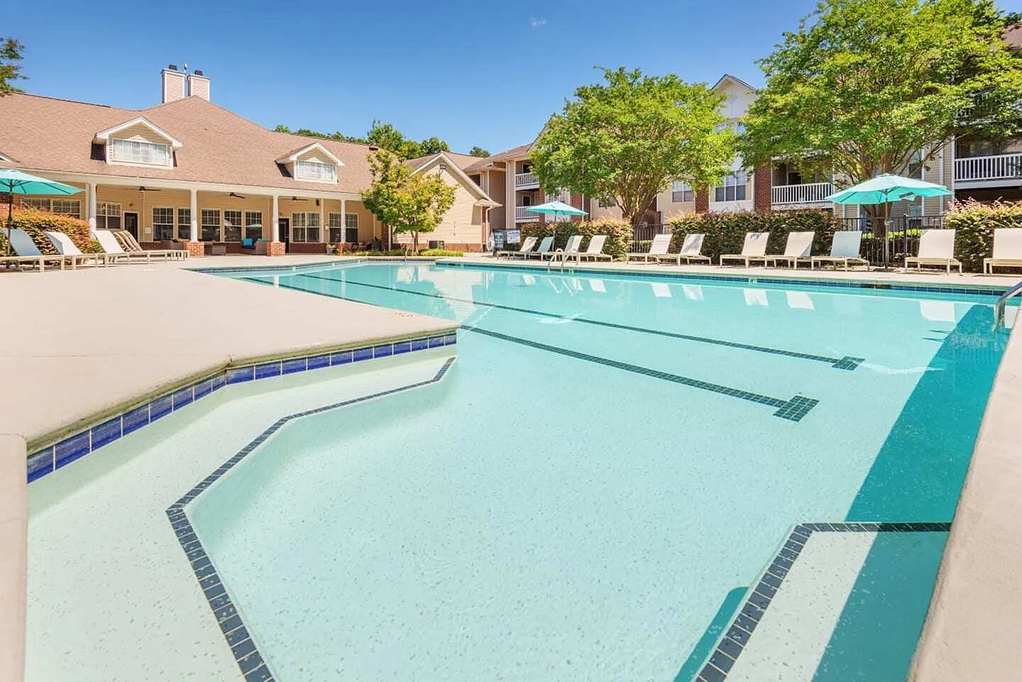 Resort-style swimming pool, lounge chairs, umbrellas, residential buildings