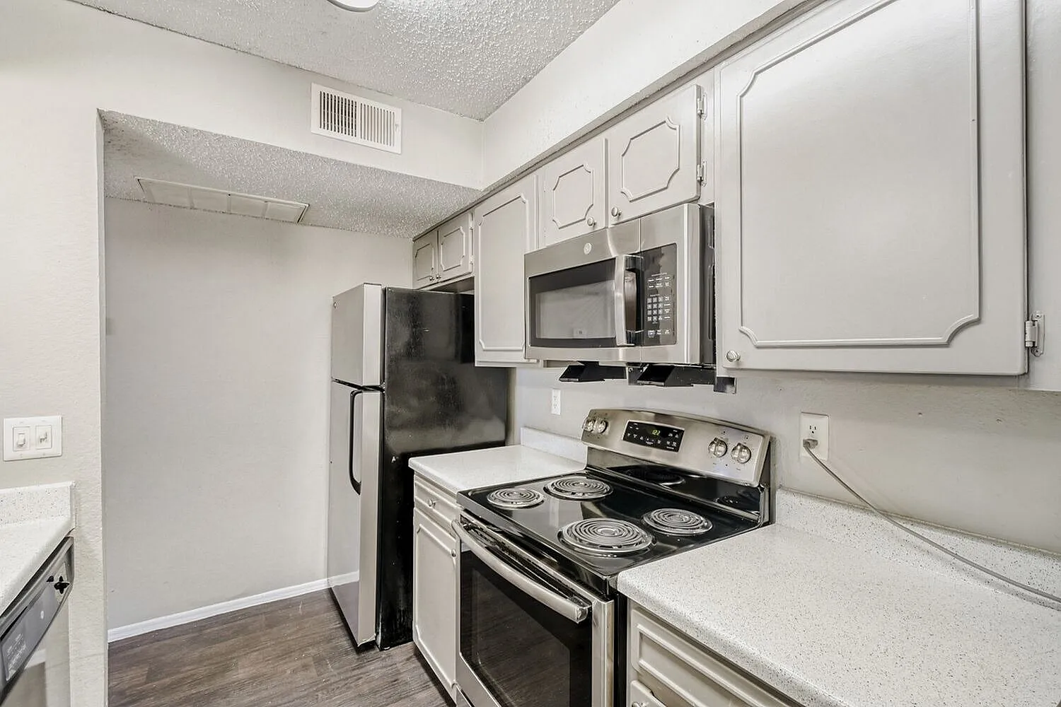 Kitchen, white cabinetry, stainless steel appliances, electric range, wood-style plank flooring