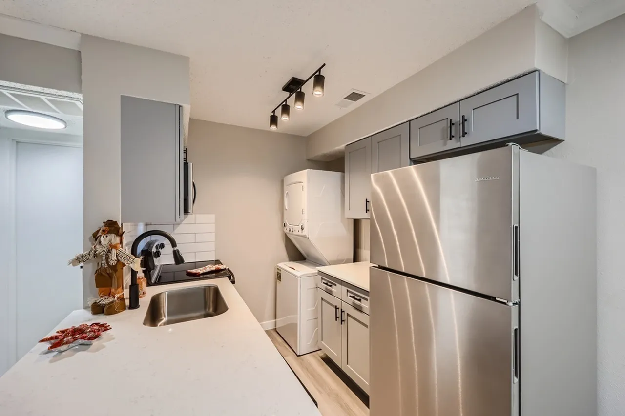 Kitchen, white quartz countertops, stainless steel appliances, gray cabinetry, wood-style plank flooring