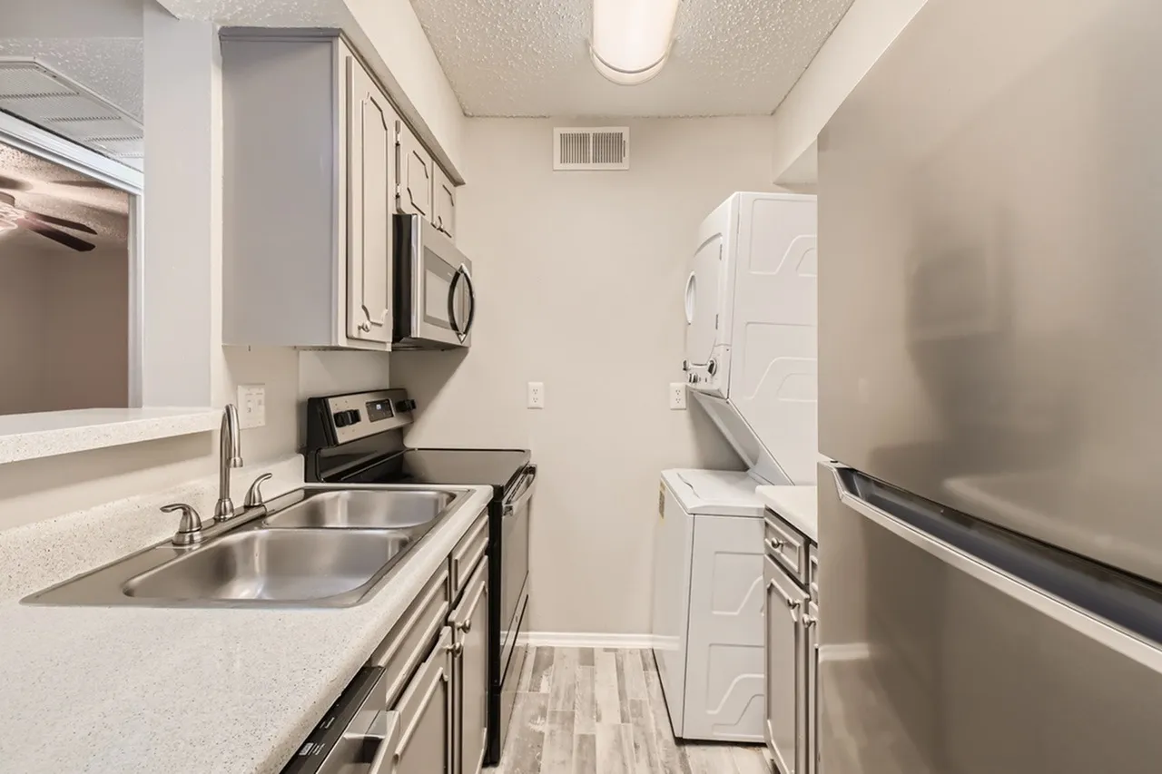 Kitchen, stainless steel appliances, quartz countertops, shaker cabinetry, wood-style plank flooring