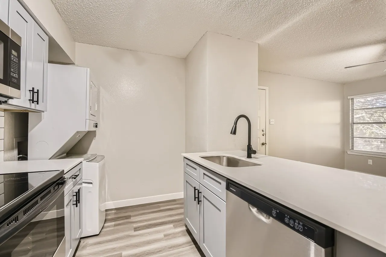Kitchen, white shaker cabinetry, quartz countertops, stainless appliances, wood-style plank flooring