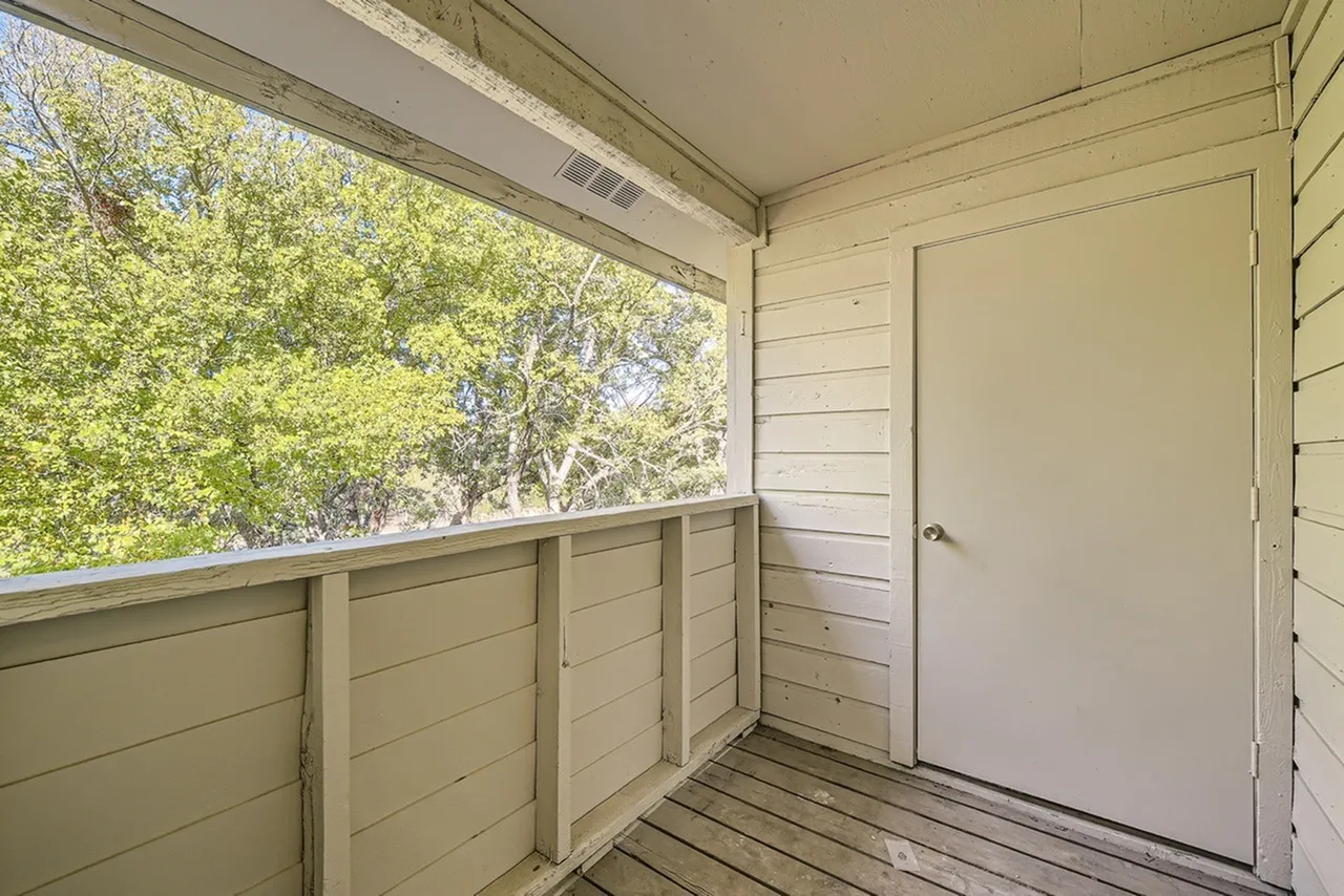 Covered patio, wood-style plank flooring, shaded windows, interior door