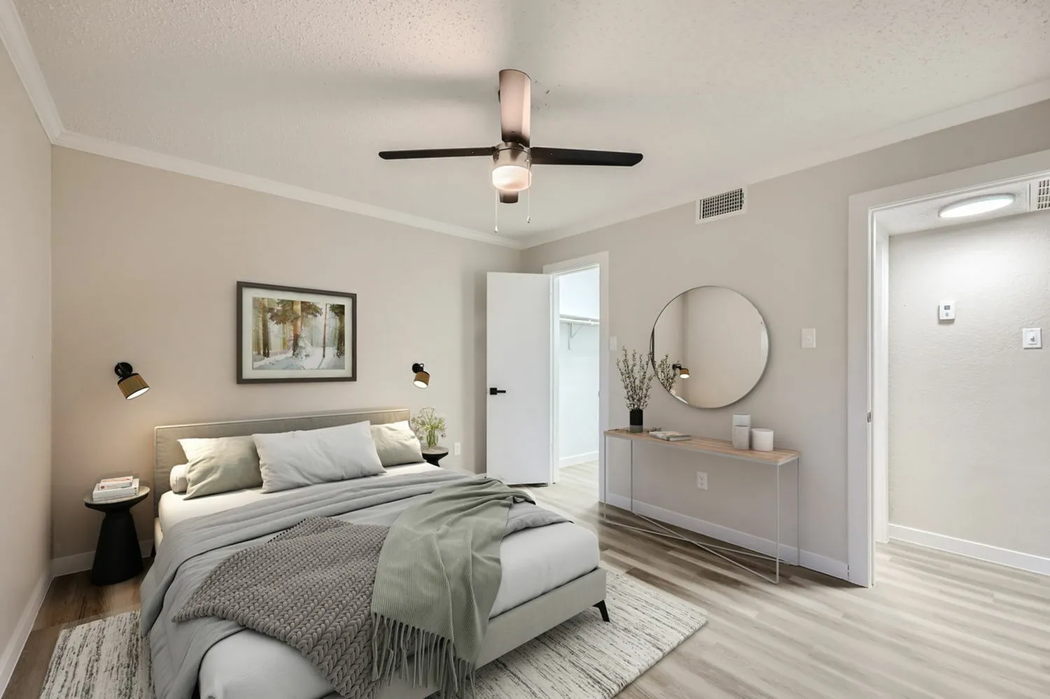 Primary bedroom, wood-style plank flooring, ceiling fan with light fixture, round mirror above dresser