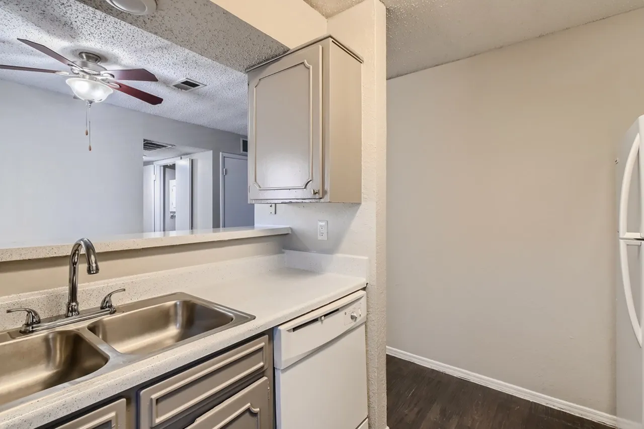 Kitchen, stainless steel double sink, white cabinetry, quartz countertops, wood-style plank flooring