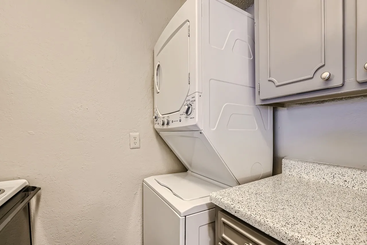 Laundry room, white washer and dryer, granite countertop, wall outlet
