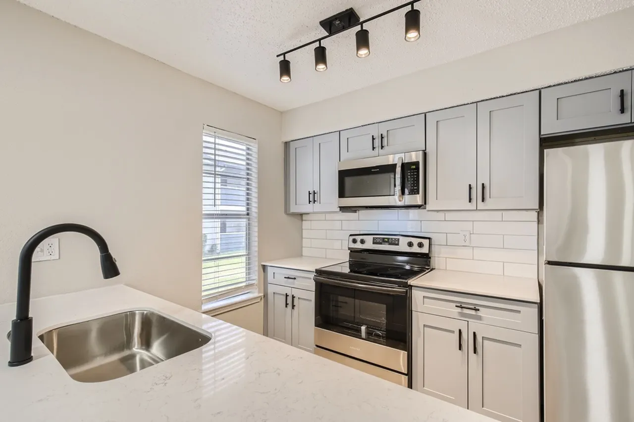 Kitchen, gray shaker cabinetry, white quartz countertops, stainless steel appliances, black gooseneck faucet