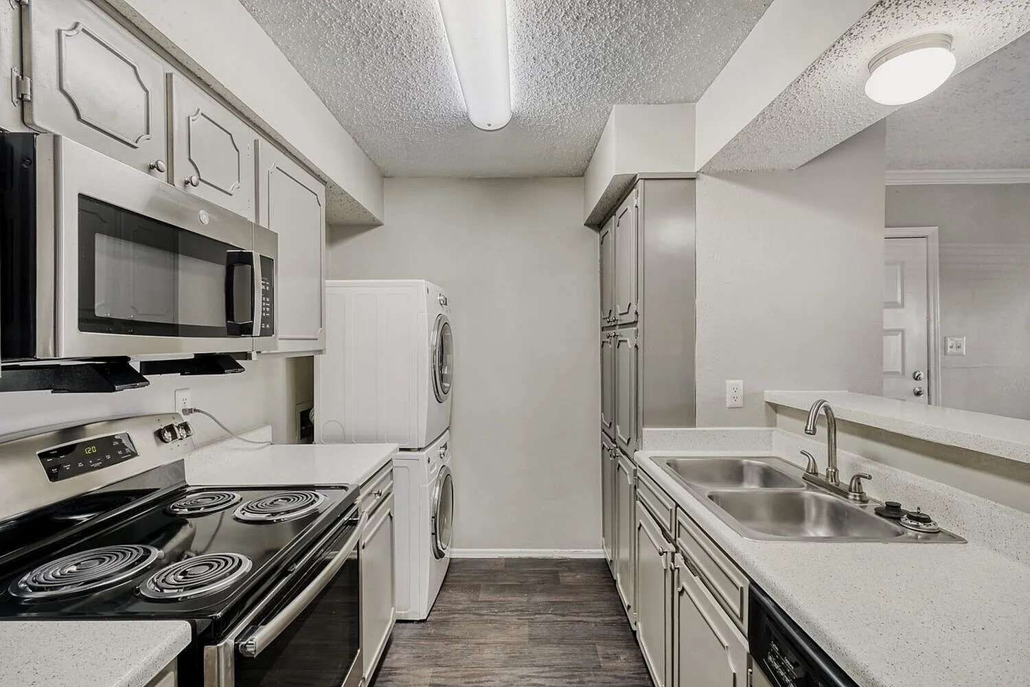 Kitchen, white shaker cabinetry, black coil stove, stainless sink, wood-style plank flooring