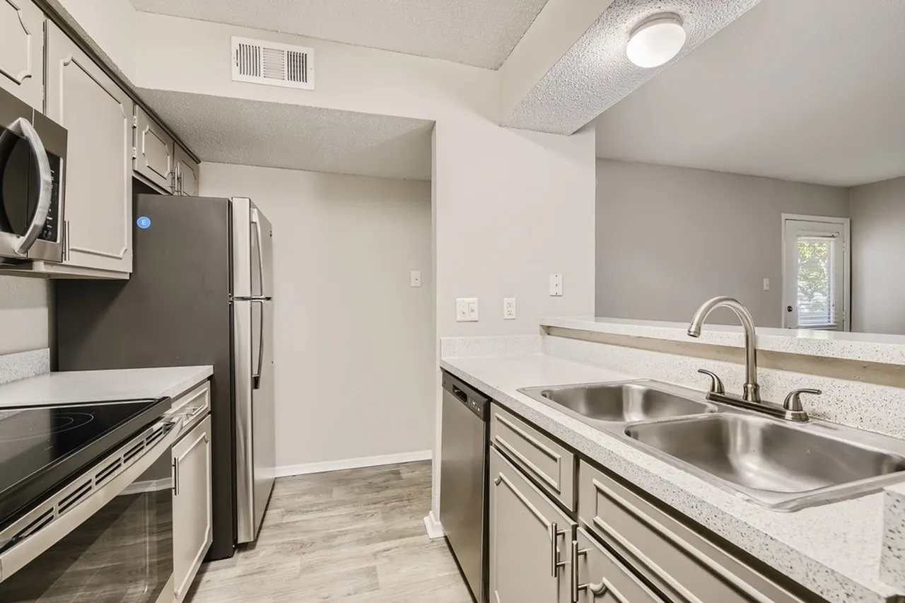 Kitchen, white shaker cabinetry, quartz countertops, stainless steel dual sinks, stainless appliances, wood-style plank flooring