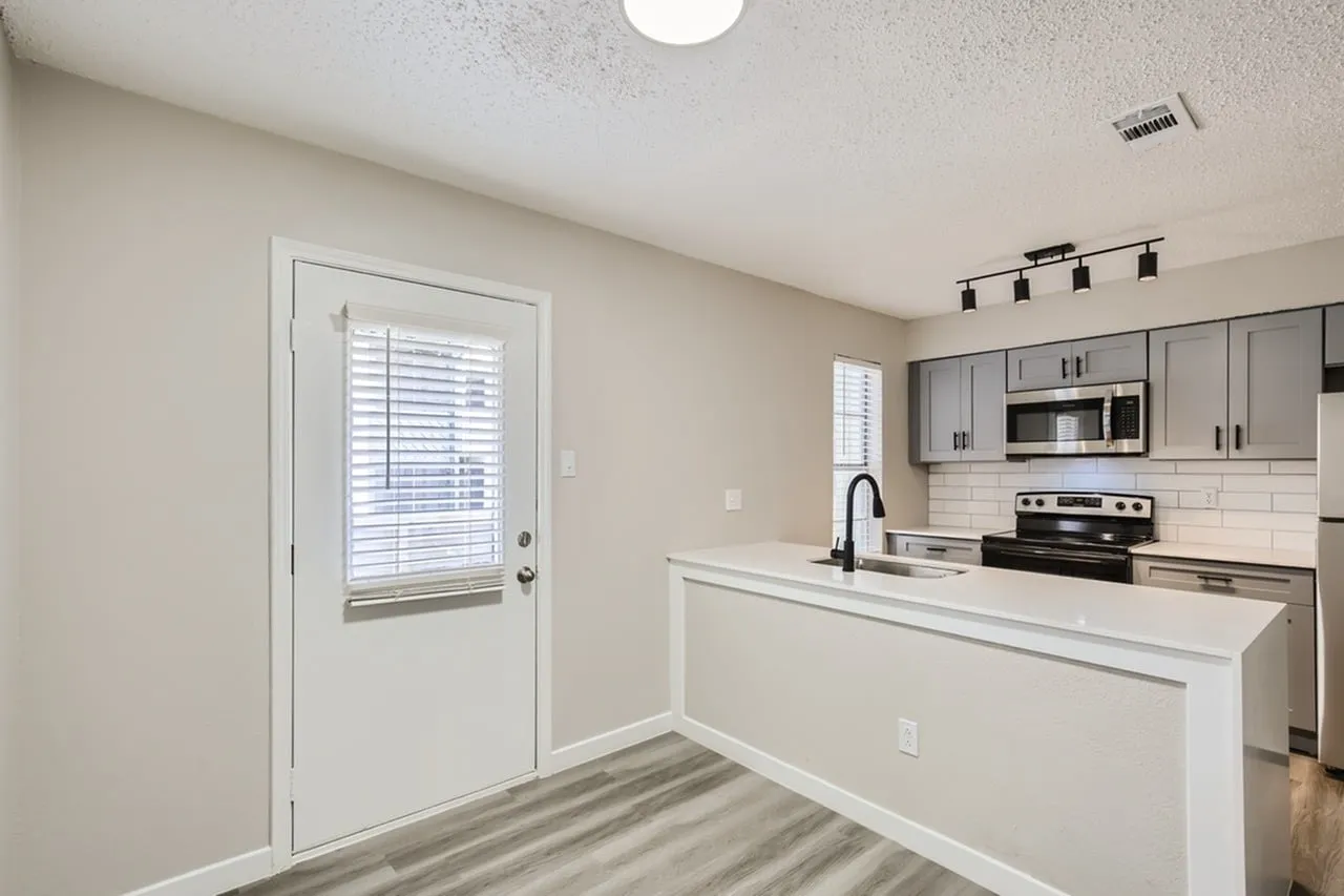 Kitchen, gray shaker cabinetry, quartz countertops, stainless appliances, wood-style plank flooring