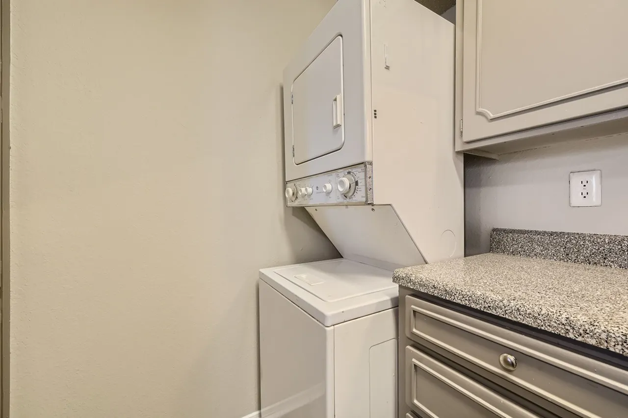 Laundry room, stacked washer dryer unit, granite countertops, stainless steel drawers