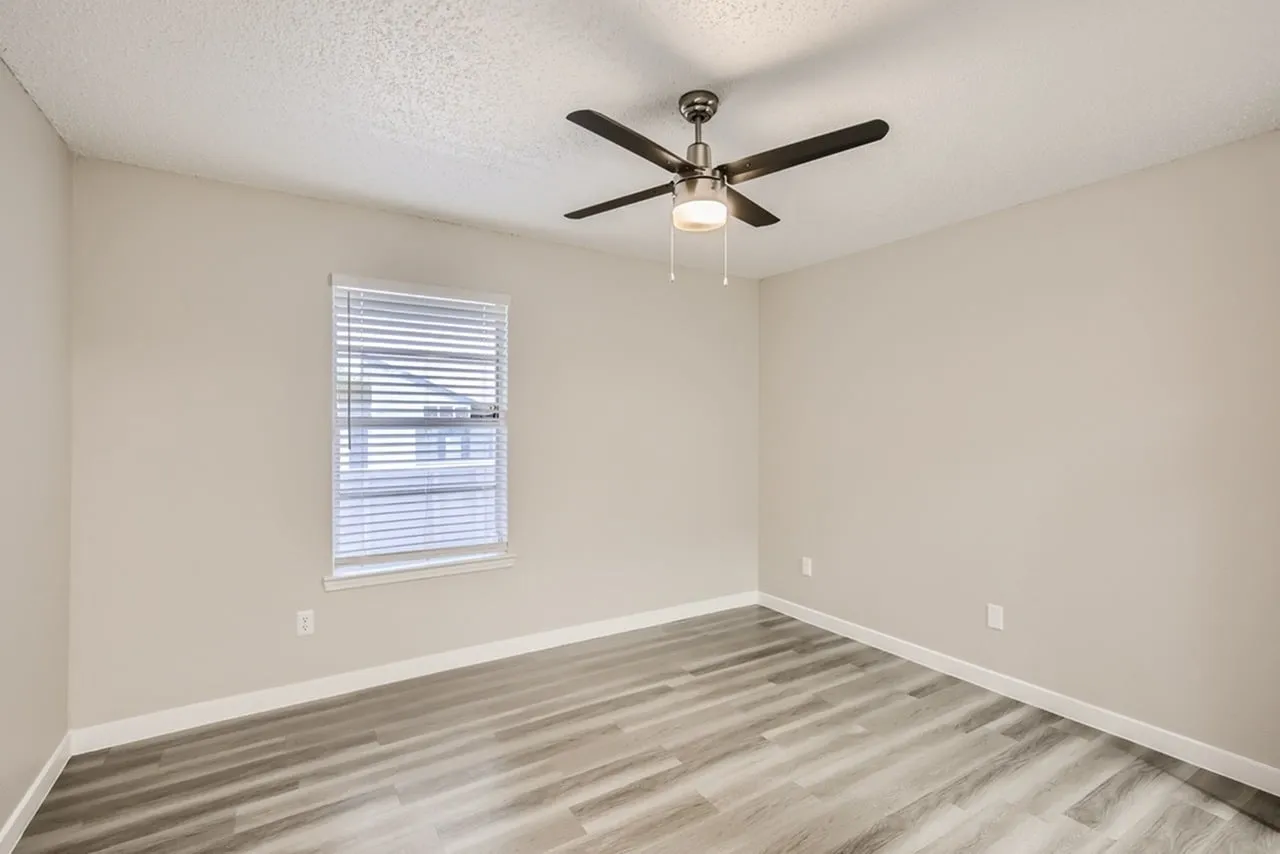 Bedroom, wood-style plank flooring, ceiling fan with light, window with blinds