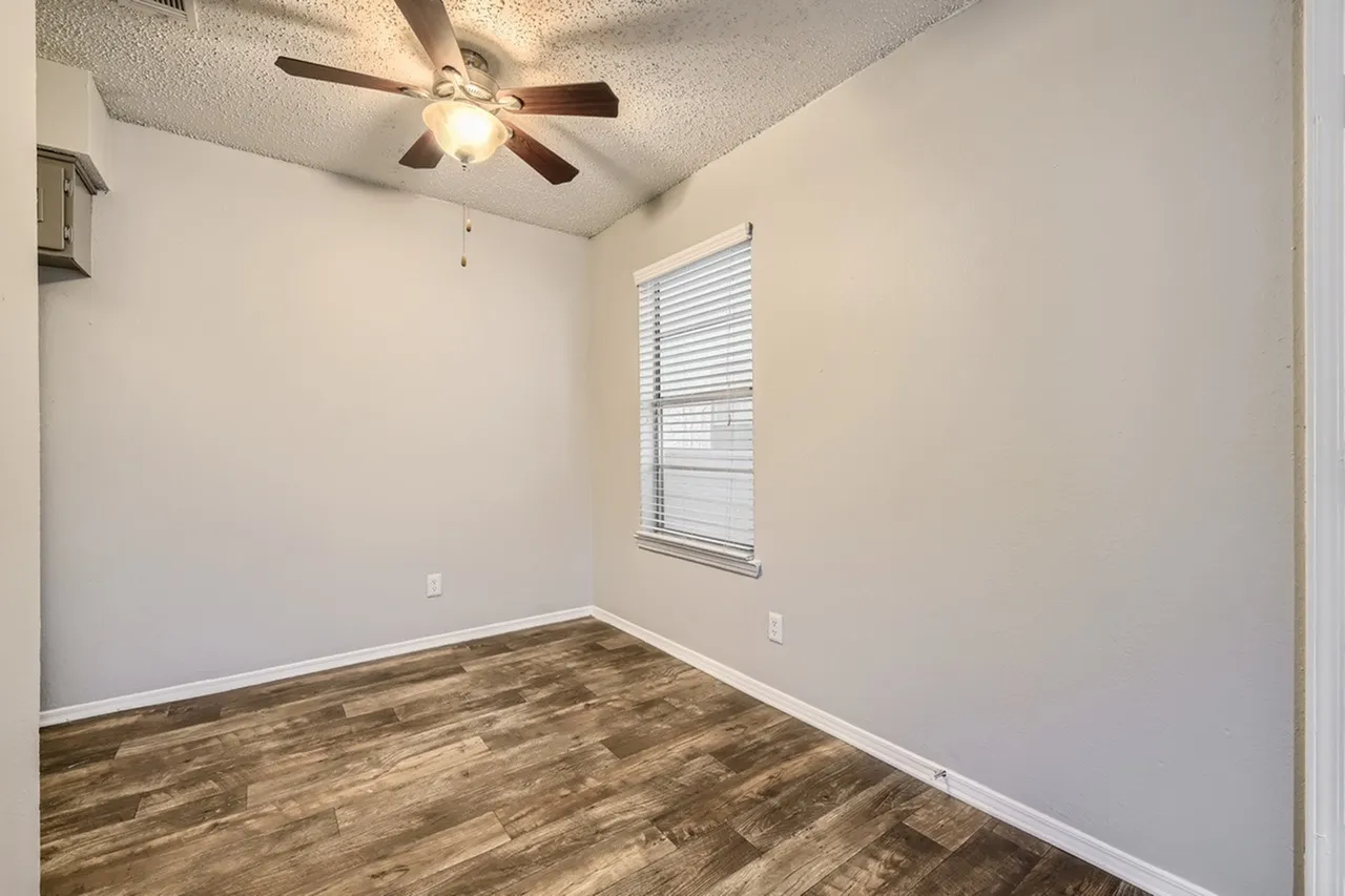 Bedroom, wood-style plank flooring, ceiling fan with light, window with blinds