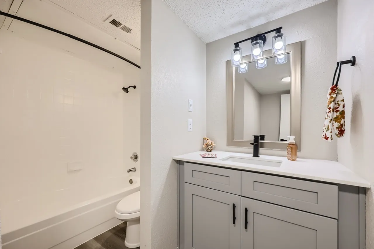 Bathroom, gray shaker cabinetry, white quartz countertop, framed mirror, chrome fixtures
