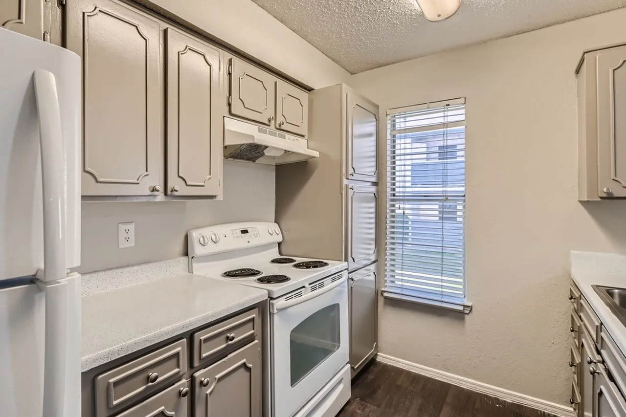 Kitchen, white cabinetry, quartz countertops, stainless electric range, refrigerator, wood-style plank flooring