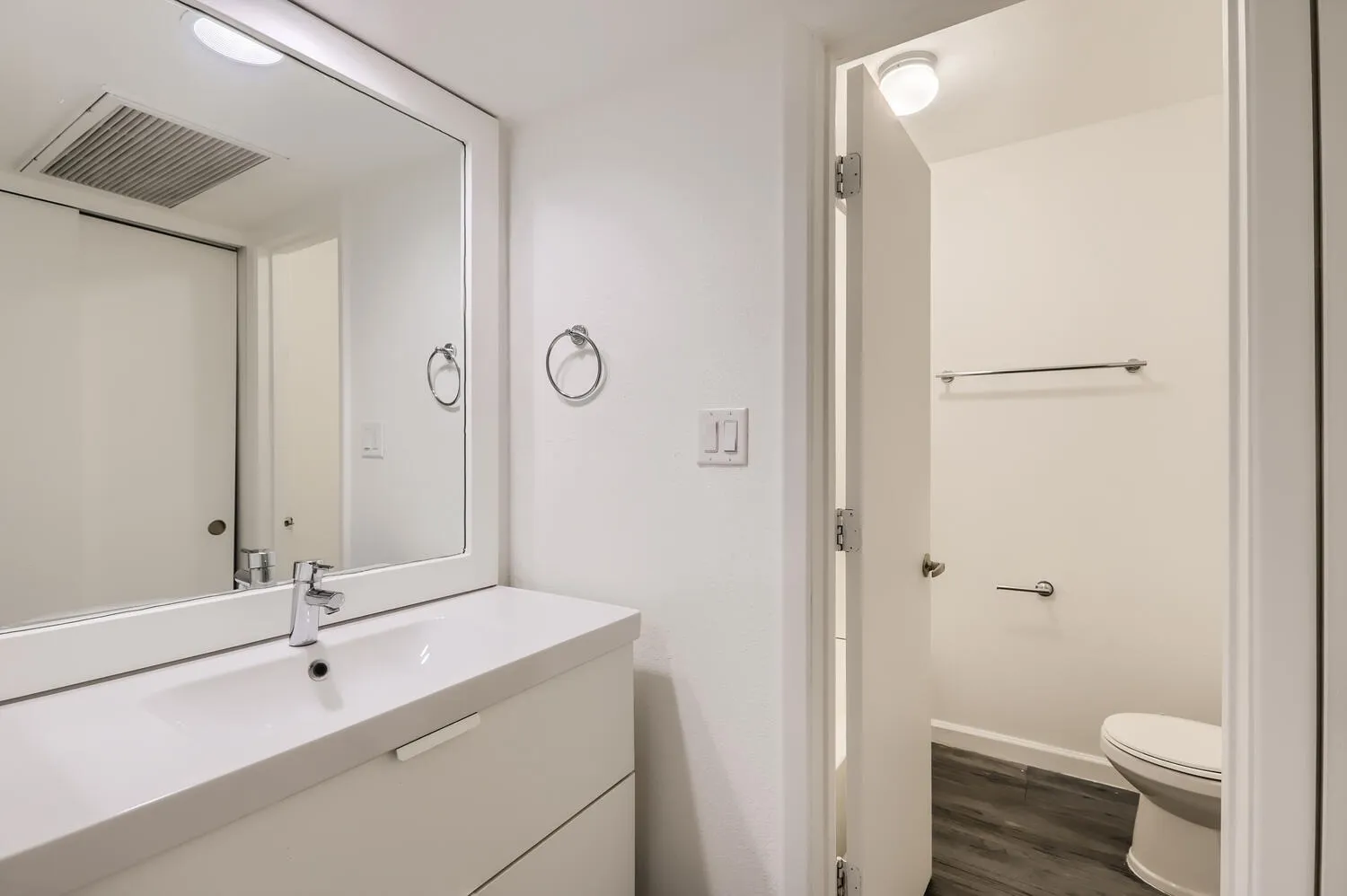 Bathroom, white floating vanity, mirror with lighting, tile flooring