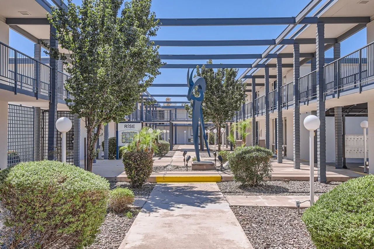Courtyard with pergola, mature trees, manicured landscaping, lounge seating, outdoor sculpture