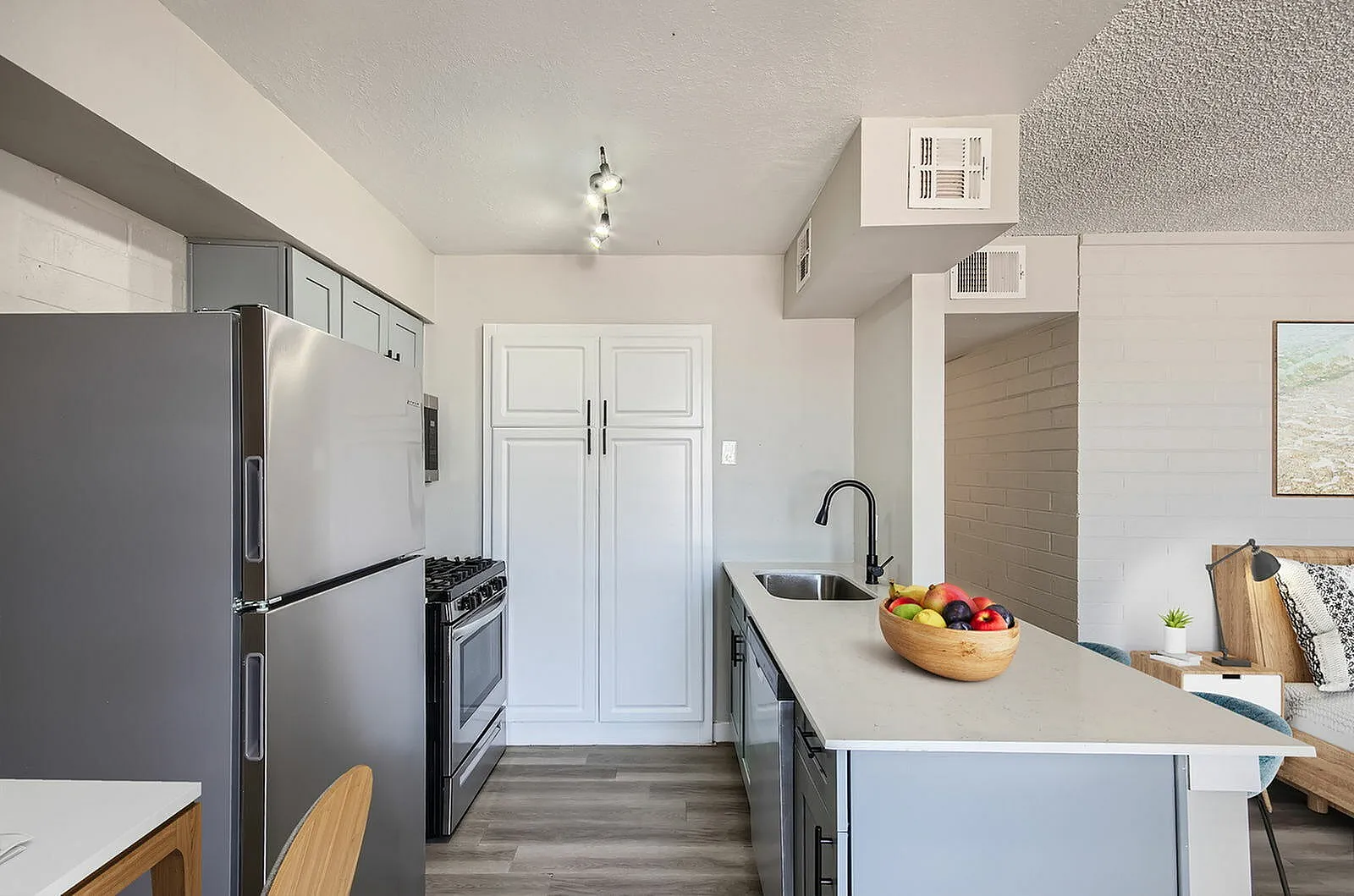 Kitchen, gray cabinetry, quartz countertops, stainless appliances, wood-style plank flooring