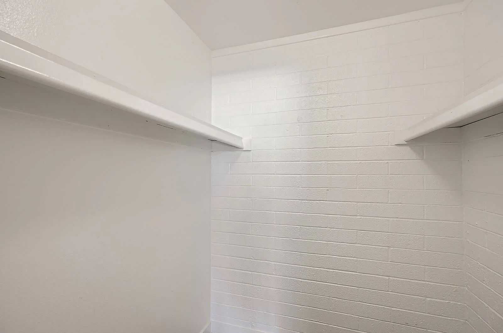 Walk-in closet, white subway tile backsplash, shelving, recessed lighting