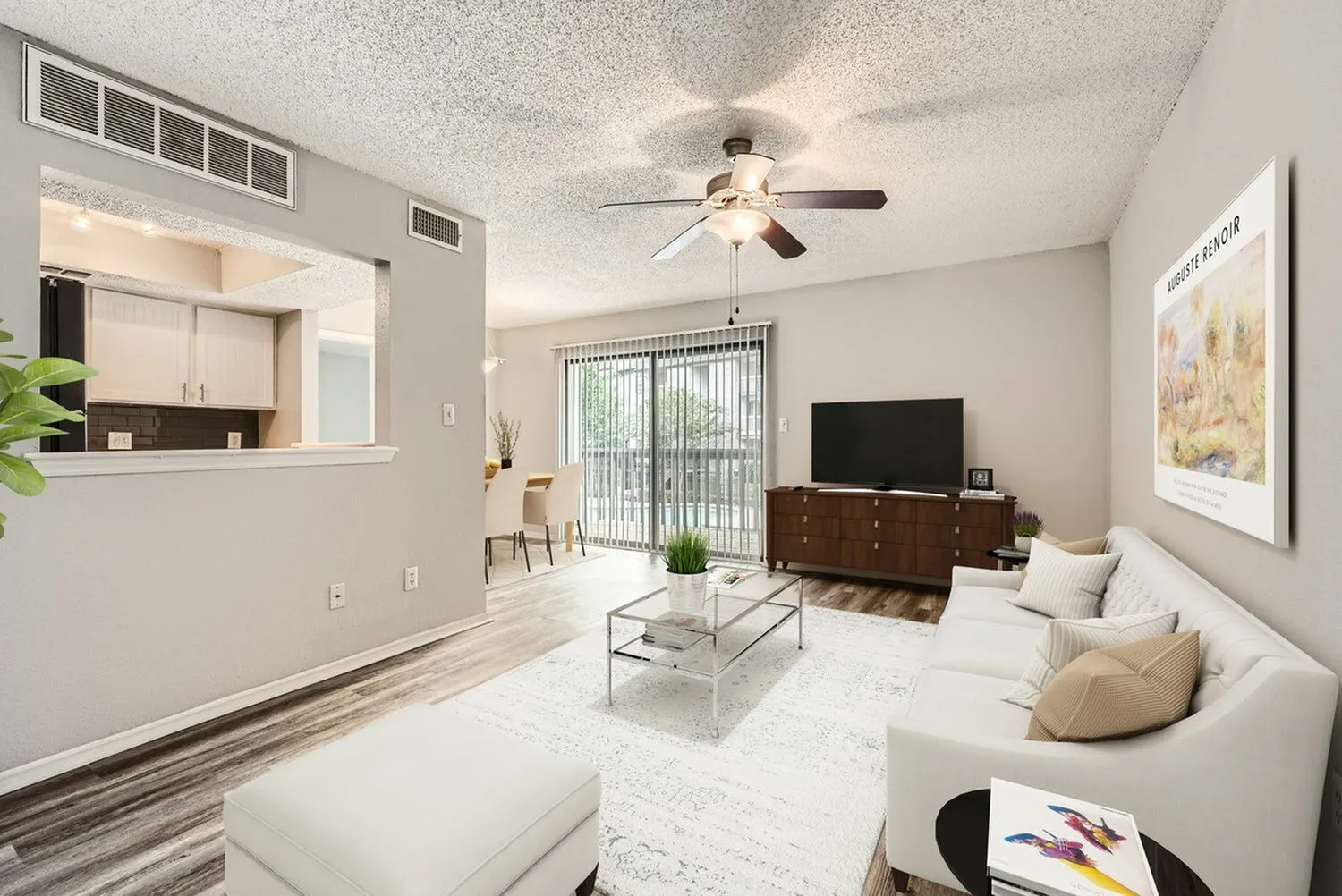 Living room with wood-style plank flooring, ceiling fan, glass coffee table, television, entryway with sliding glass door