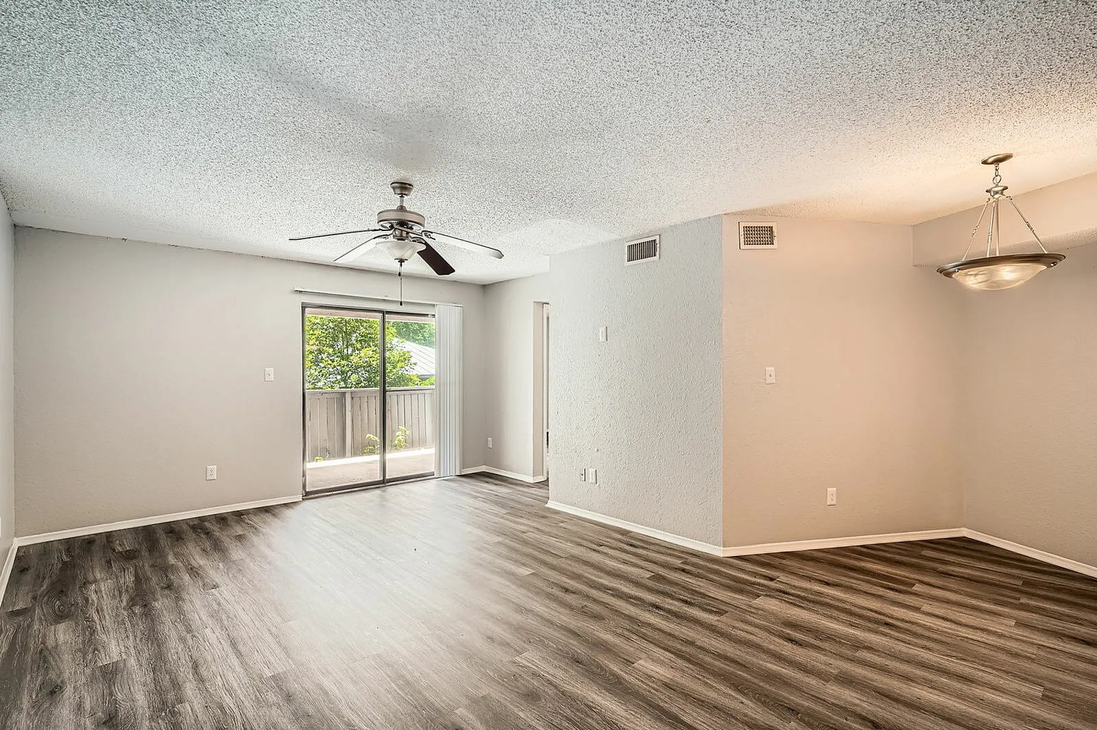 Living room, wood-style plank flooring, sliding glass patio door, ceiling fan, recessed lighting