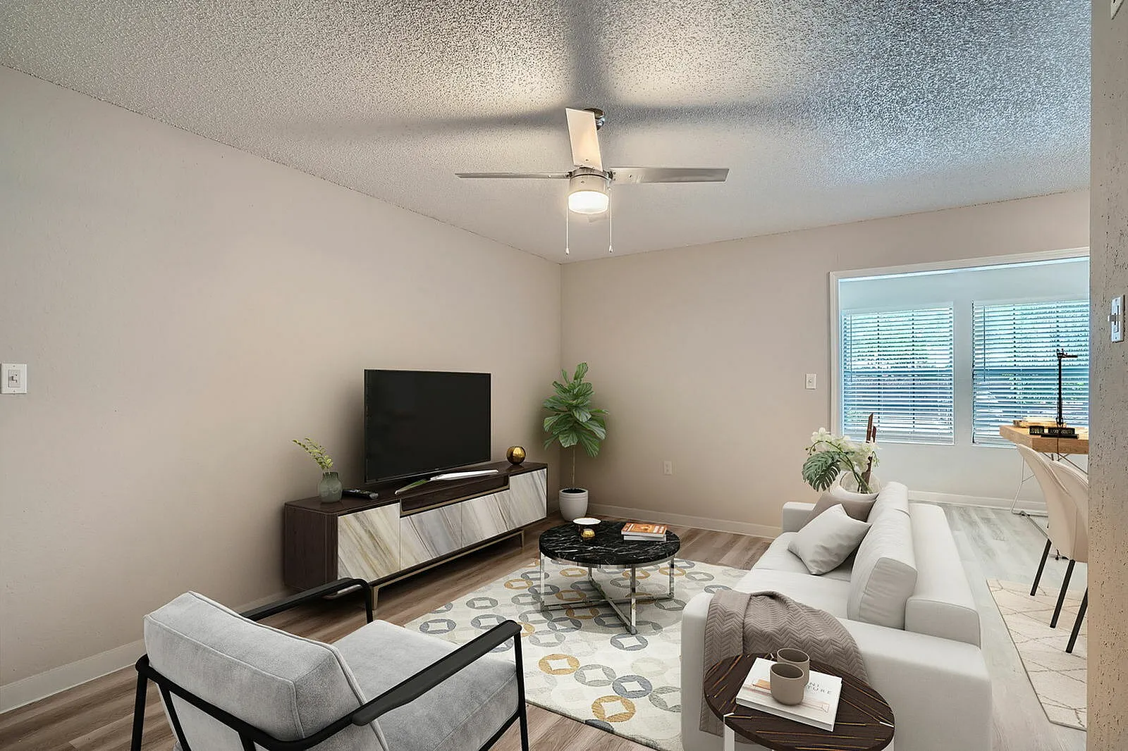 Living room, wood-style plank flooring, ceiling fan, gray upholstered seating, television