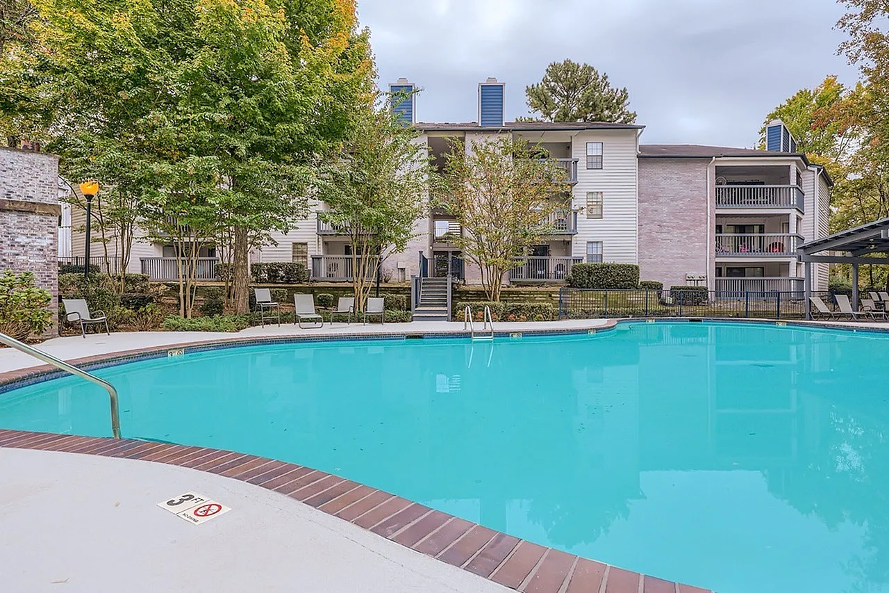 Swimming pool, brick decking, residential buildings, mature trees, autumn foliage