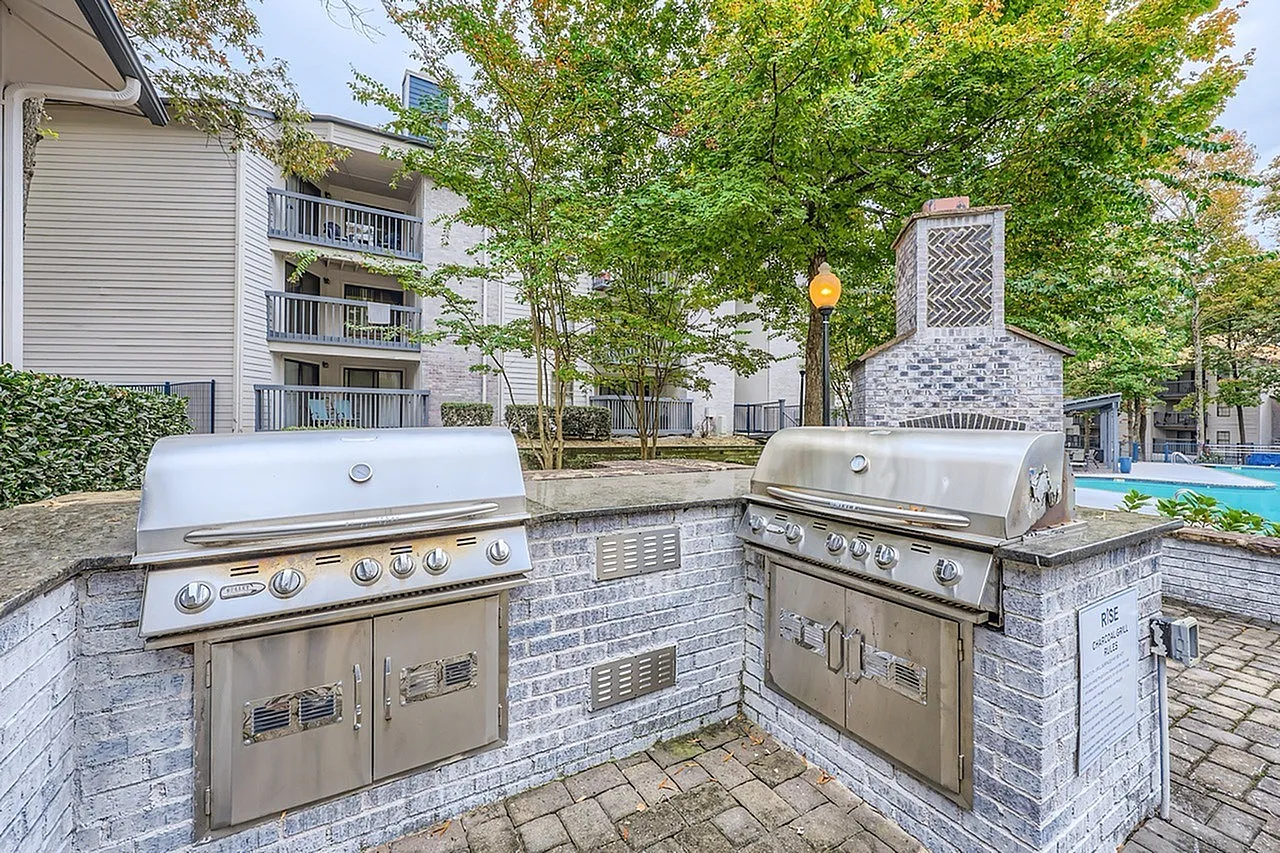 Outdoor kitchen, dual stainless grills, brick countertops, patio seating area