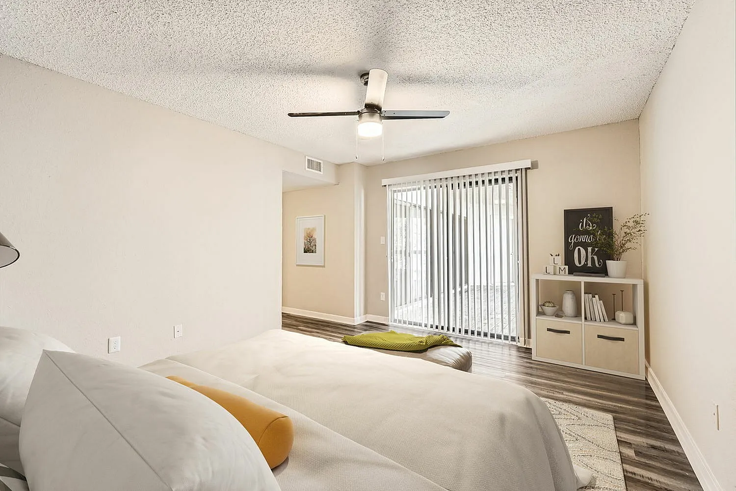 Primary bedroom, wood-style plank flooring, ceiling fan, vertical blinds, built-in shelving