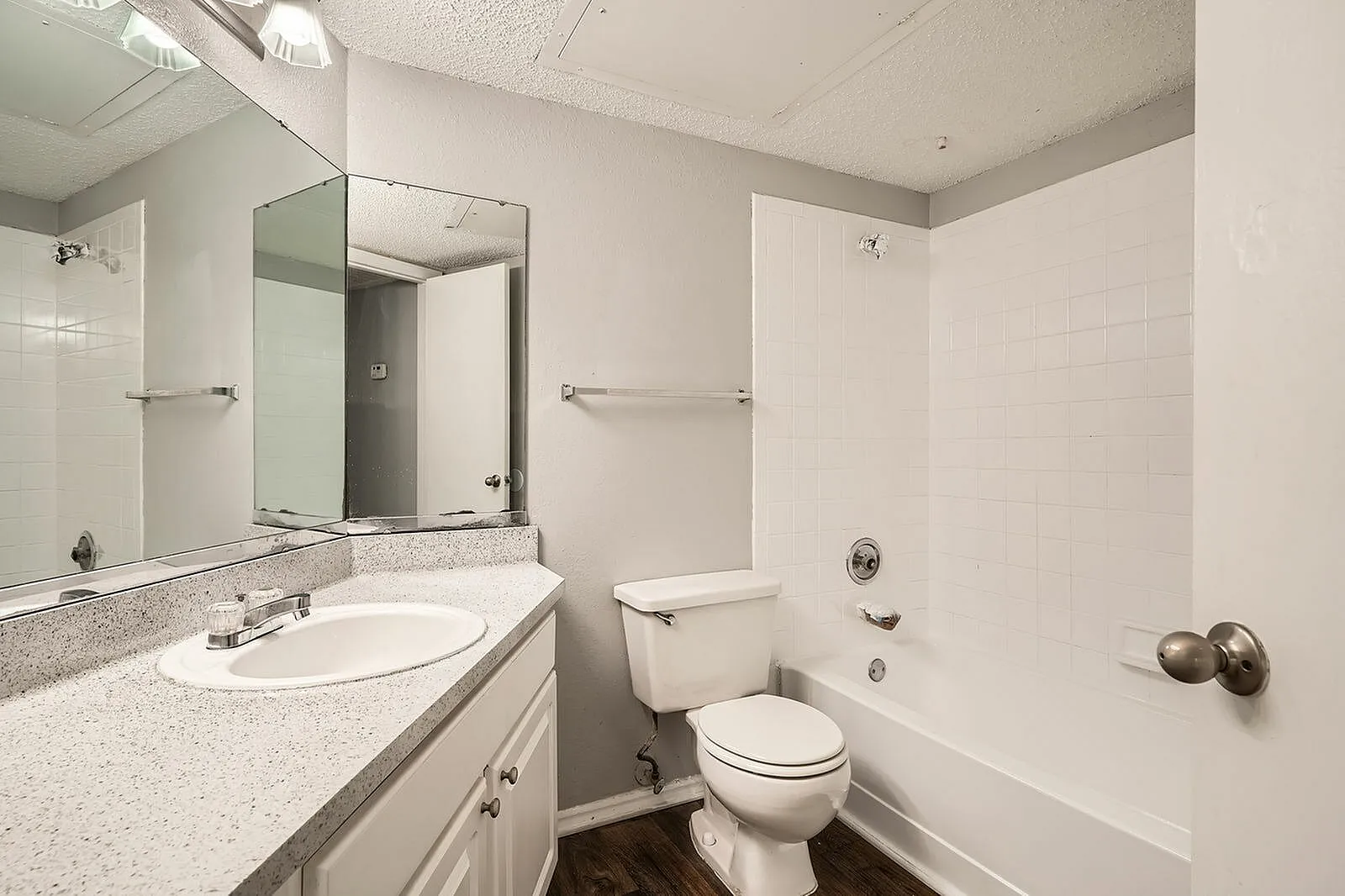 Bathroom, quartz countertops, framed mirror, white cabinetry, wood-style plank flooring